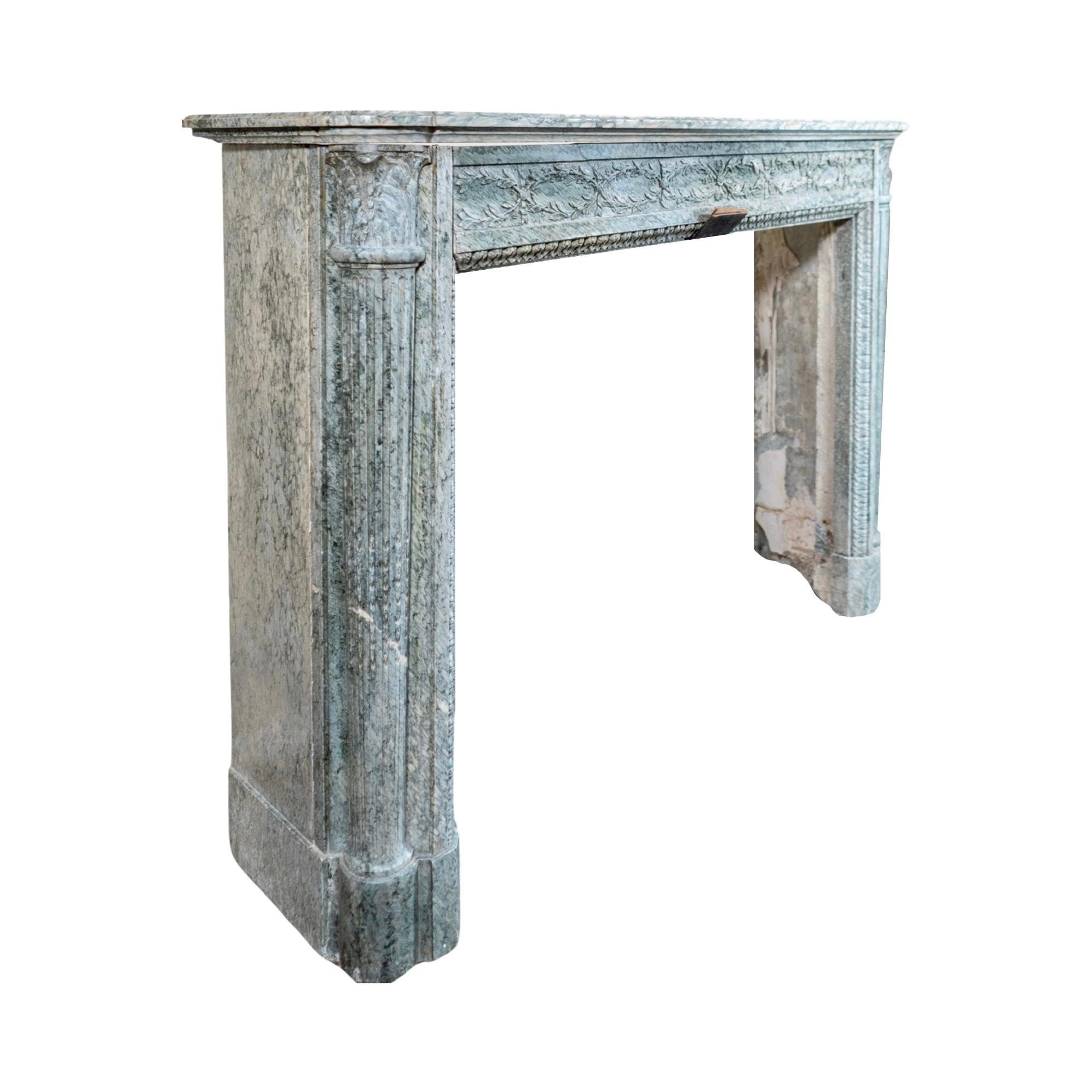This French Marble Mantel is perfect for completing any traditional look. From the 18th century. It is made out of Estours Green Marble from France, in an emerald green color. Carving designs along the legs and center top level add a touch of