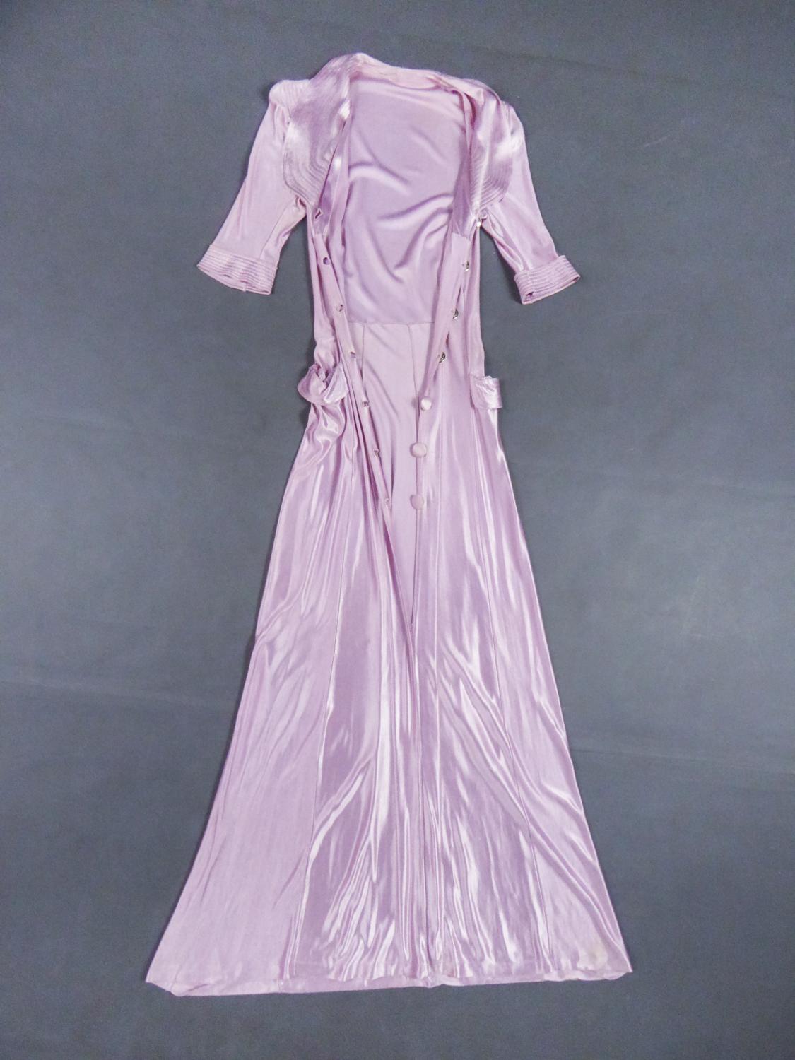 Circa 1935/1940
France

Astonishing indoor or evening coat dress in pink purple and yellow gold synthetic fibranne from the 1940s. Heavy and very fine fabric with an excellent 