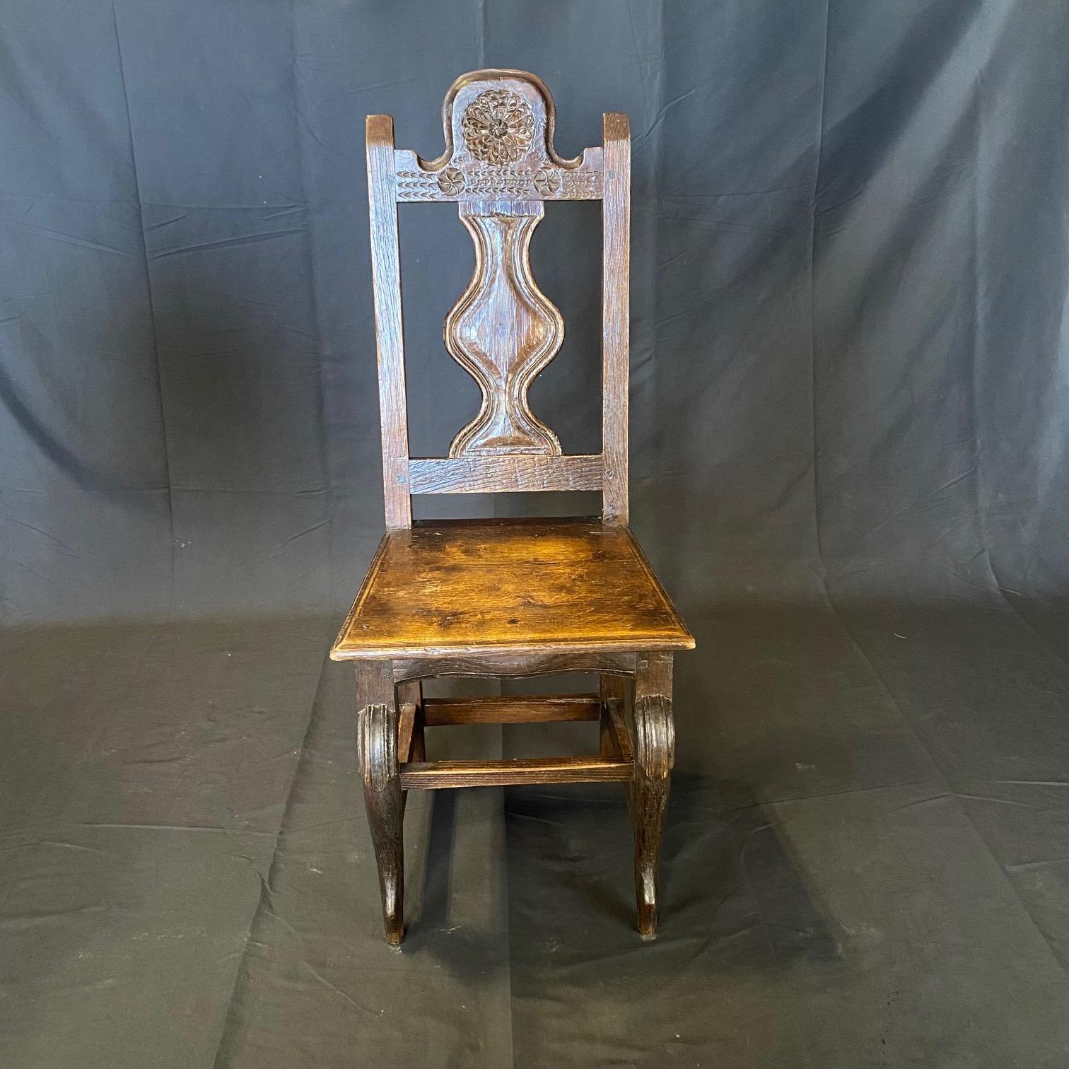 Stunning hand carved set of six French oak Renaissance Revival dining chairs with fluid lines and graceful proportions. The carved open work back rests highlight the center carved panel with curved carved fluid center with floral motif on the head