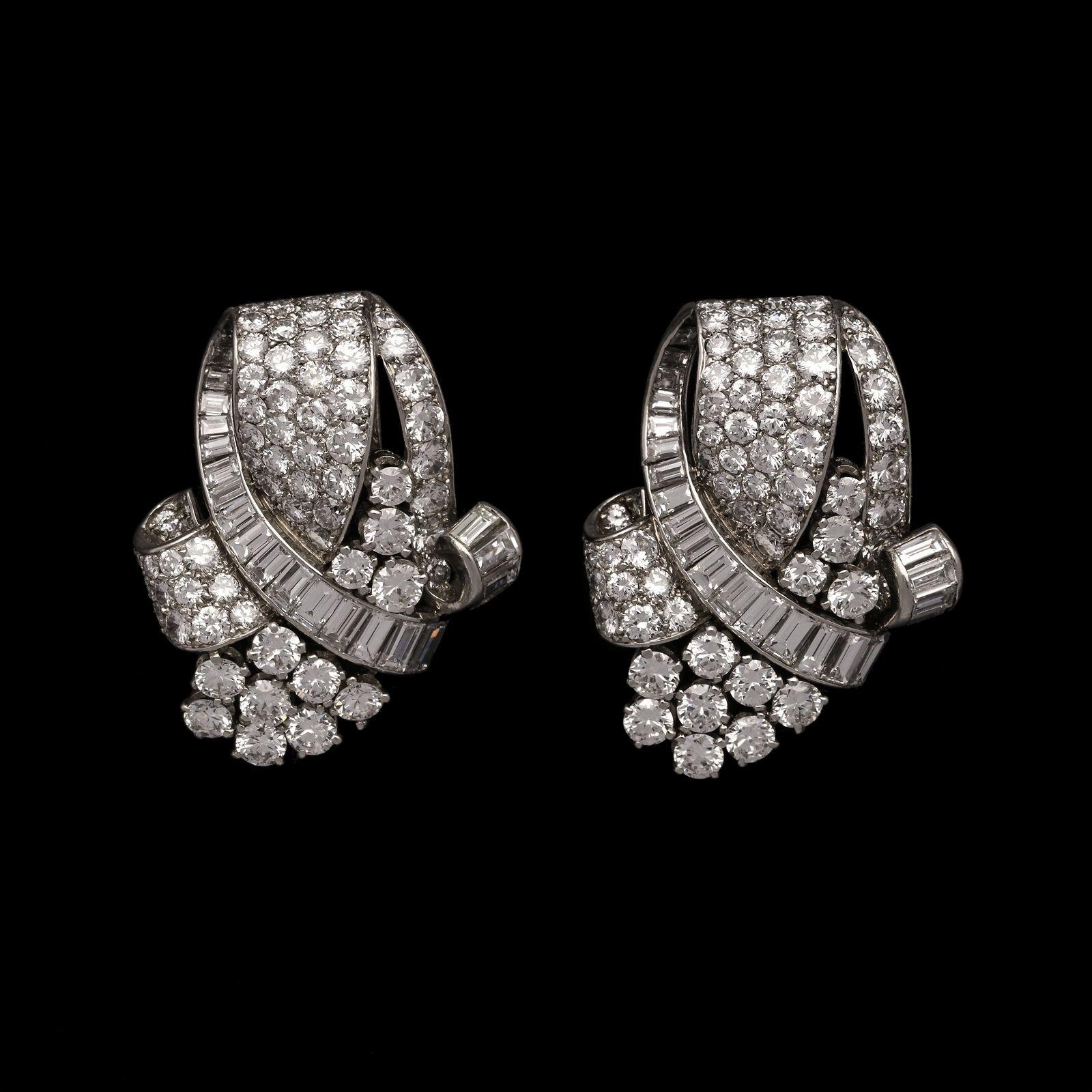 A stunning French diamond double clip brooch c.1935, the matching pair of clips have an asymmetric three-dimensional form and are set throughout with round brilliant cut diamonds in both pavé and claw settings as well as baguette cut diamonds in