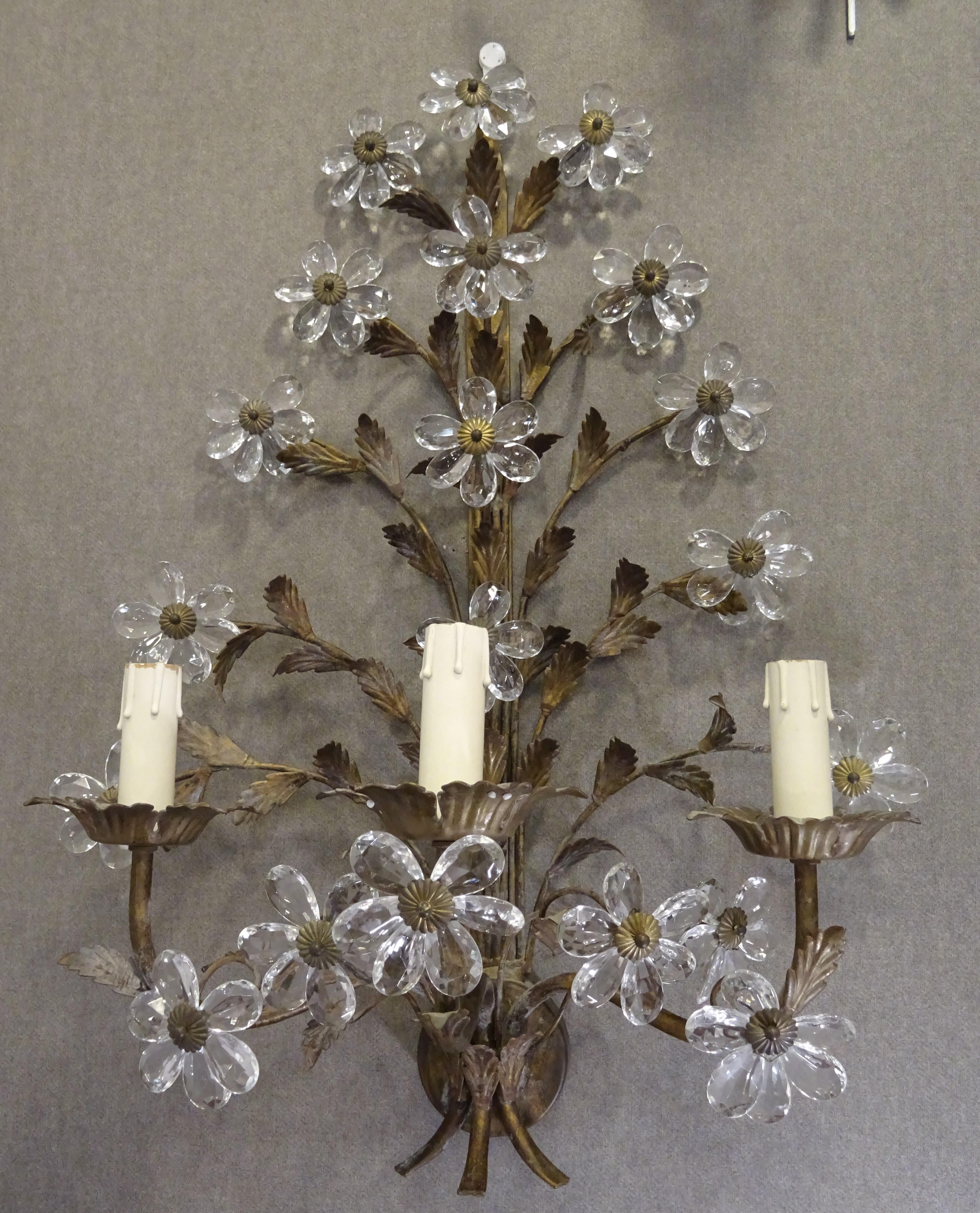 Stunning couple of wall sconces in faceted and cut white crystal making daisies an wrought iron as a structure. They are electrified and work perfectly.
They are a beautiful sconces with a lot of daisies in cut crystal, French school, circa 1940,