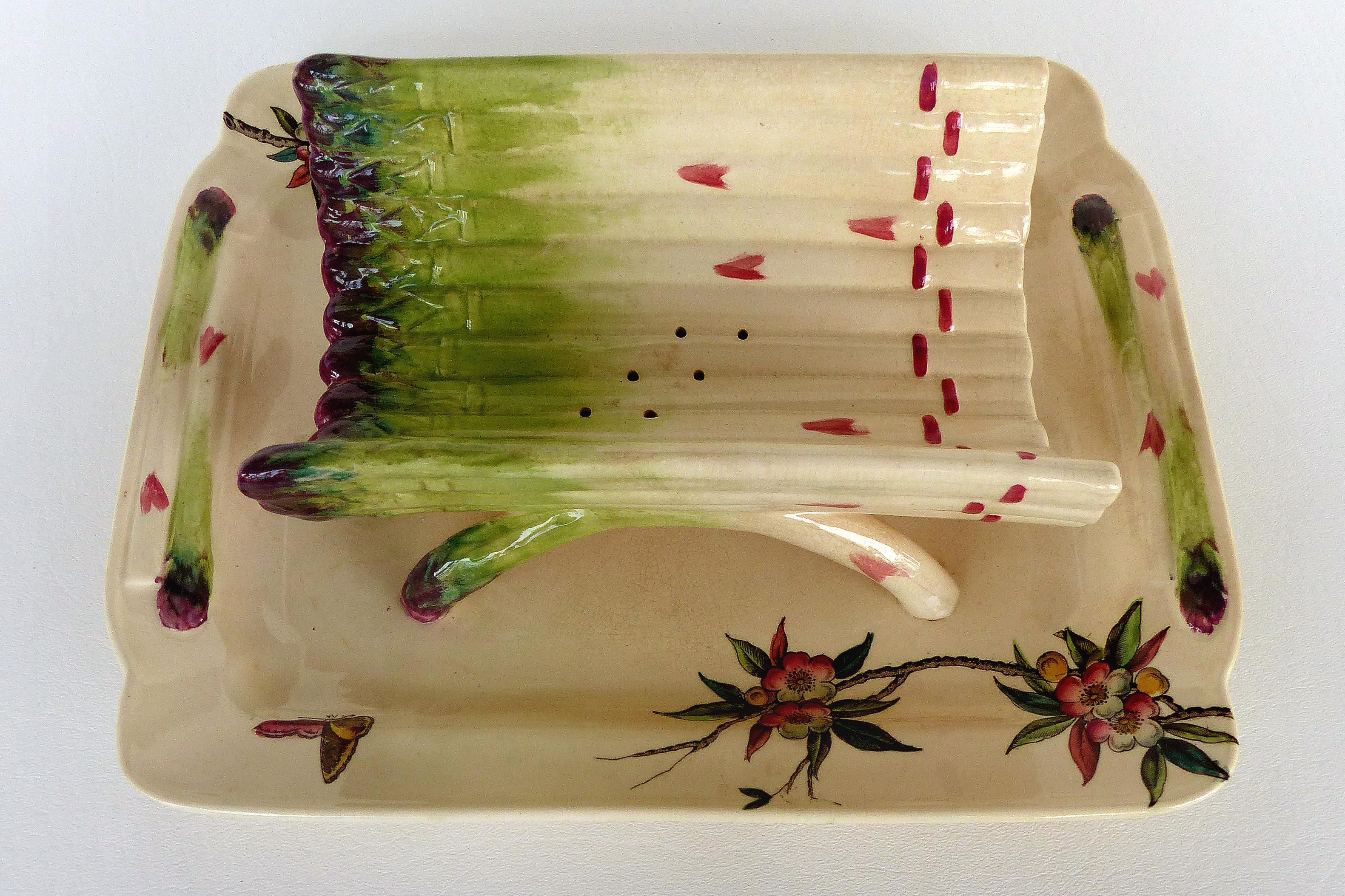 French Faience Asparagus Strainer and Serving Dish

Offered for sale is a late 19th-century hand-painted French faience asparagus strainer and serving dish. The underplate portion is hand-decorated with flowers and bird motifs of the period. There