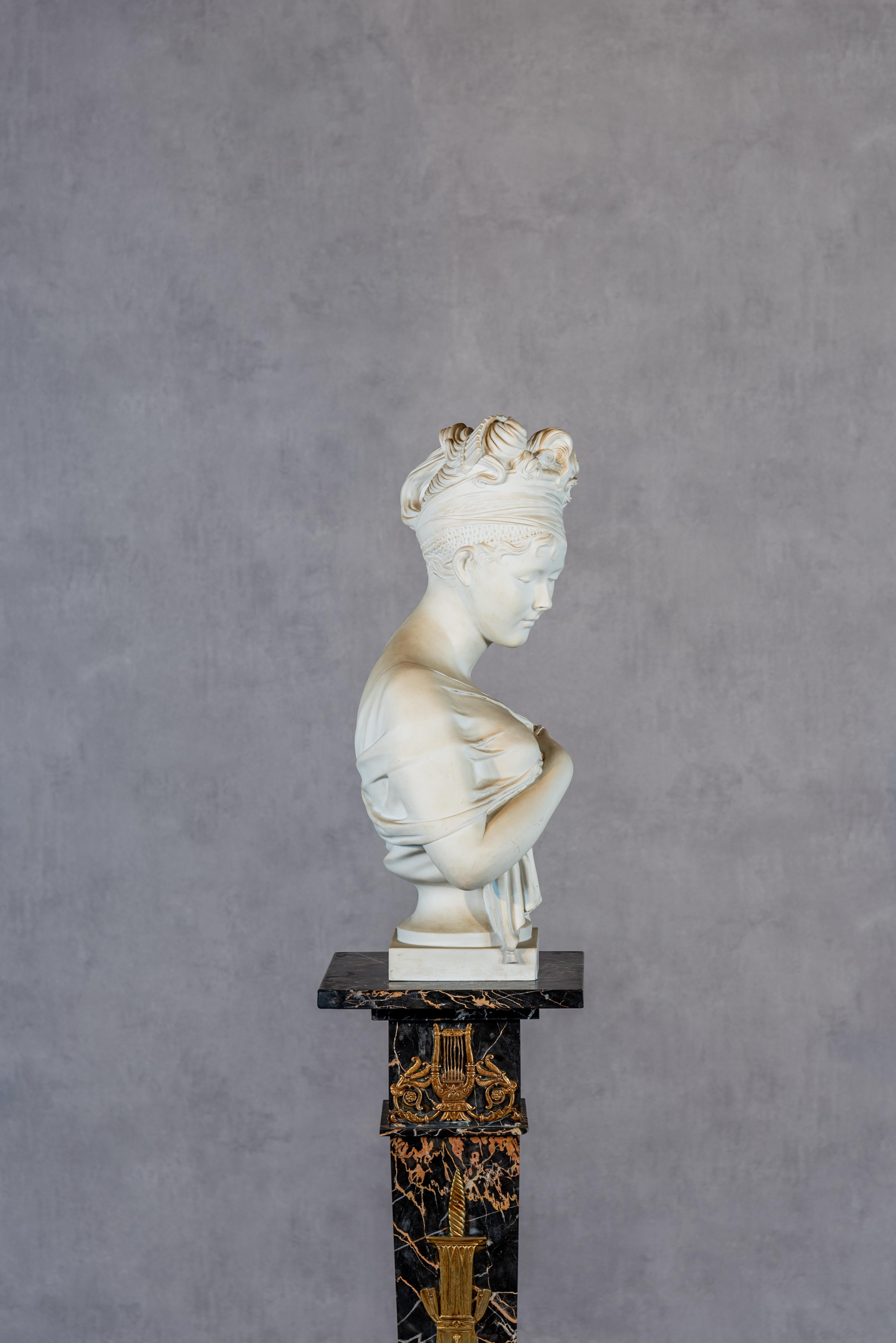 Discover the timeless beauty of this exquisite French Faience Bust of Madame Recamier, a tribute to the renowned sculptor Jean-Antoine Houdon. Made of authentic Sèvres faience, this piece is a testament to the traditional 