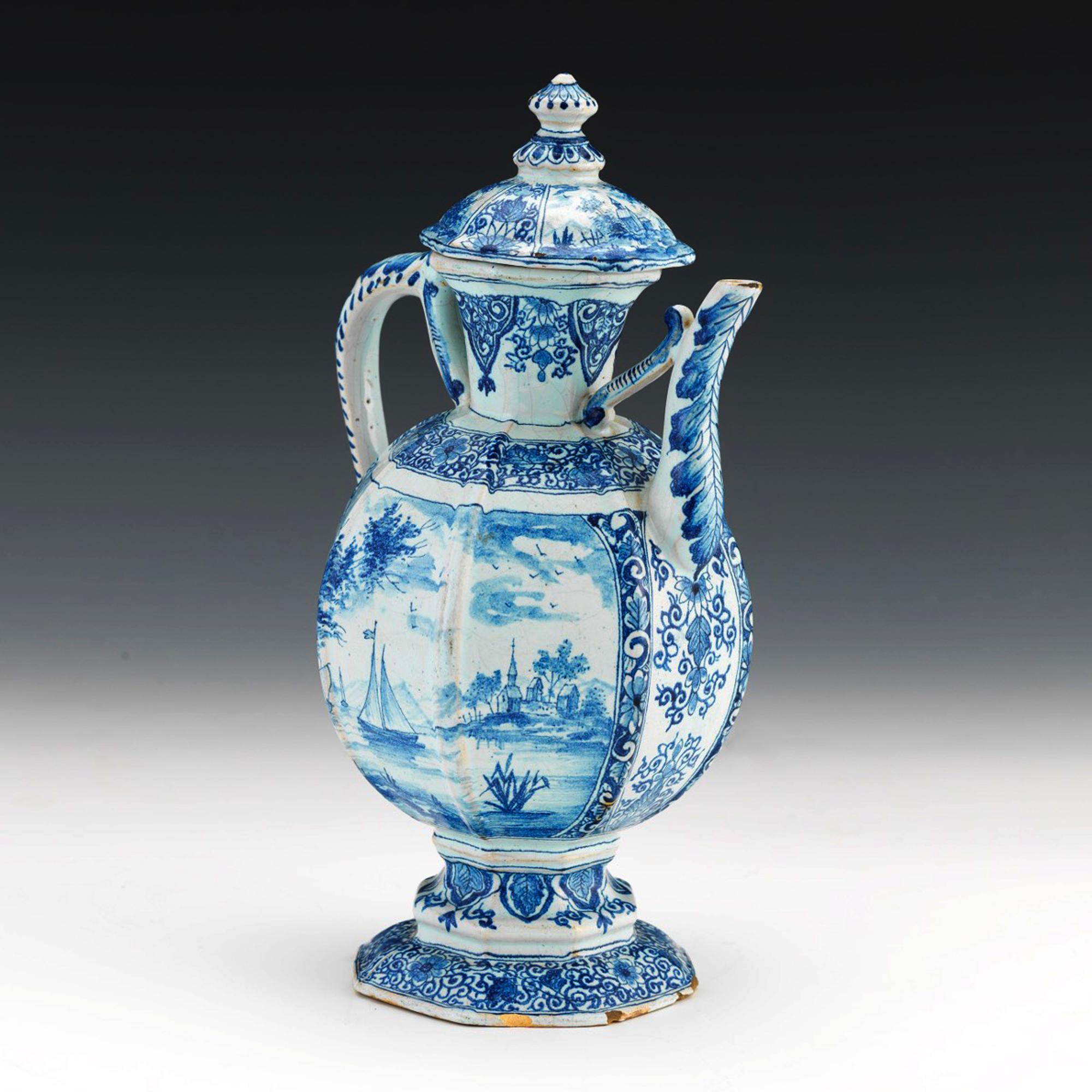 French Faience covered blue & white jug,
circa 1900
The underglaze blue and white faience jug is raised on a hollow foot. The body has eight panels. One side with a sailing ship with ships seen in the background with a small village with a church