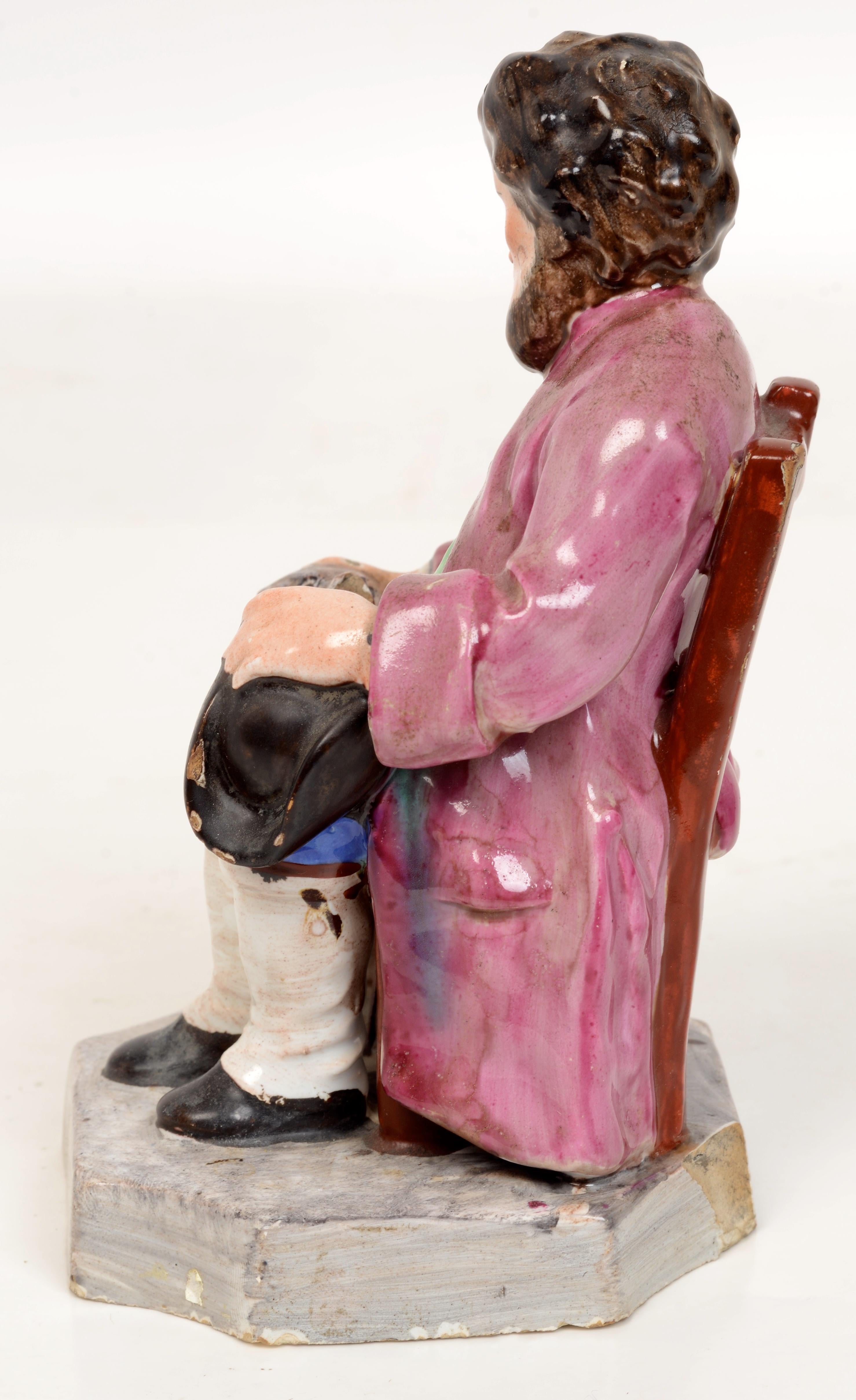 Early 19th c French Faience Earthenware Seated Figure From Les Islettes Factory Which Was Founded in 1764 Near Reims in Northern France. Representing a grandfather seated on a chair stroking his dog. 
Trent Antiques has been a respected name in