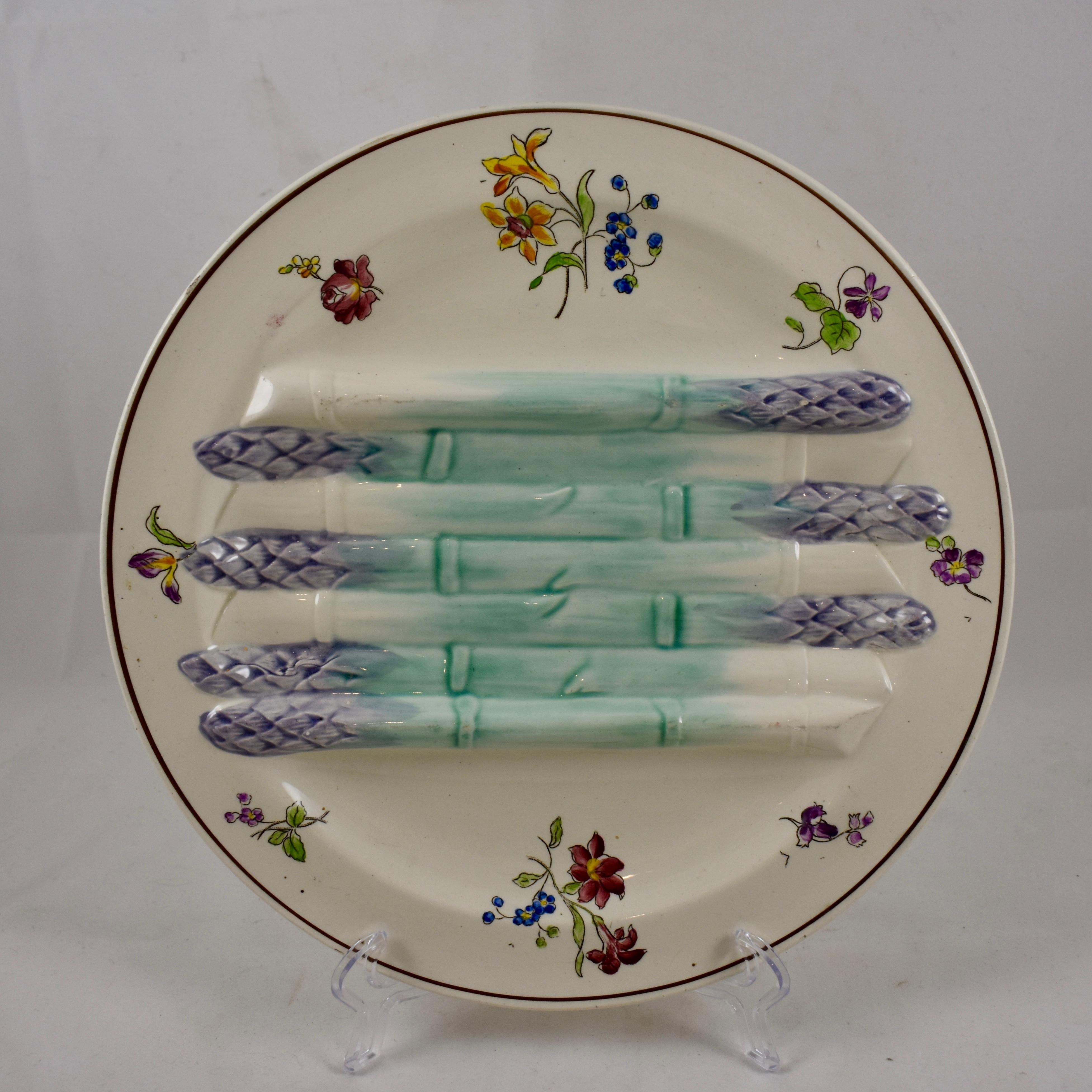 A French earthenware, majolica glazed asparagus plate, molded by Longchamp in the Pompadour pattern, circa 1890-1910. Seven raised asparagus glazed in turquoise and lavender lay across the centre of the plate forming a deeper sauce well on either