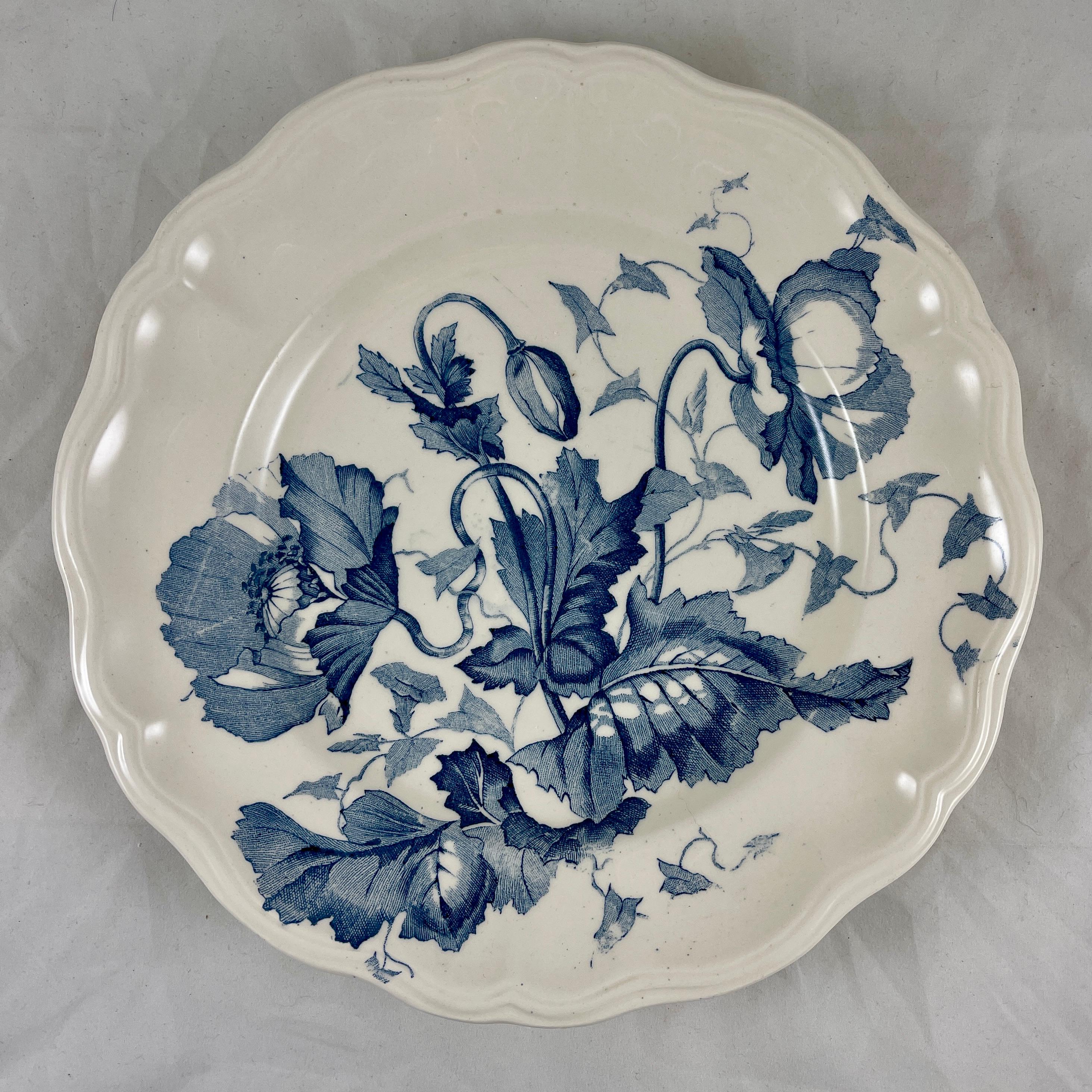 From the Longchamp Faience factory, founded in Burgundy, France in 1832, Terre de Fer plates in the Pavots pattern, circa 1890-1912.

Pavots, French for Poppy, was designed by Robert Charbonnier in the Art Nouveau style. 
The floral pattern is a