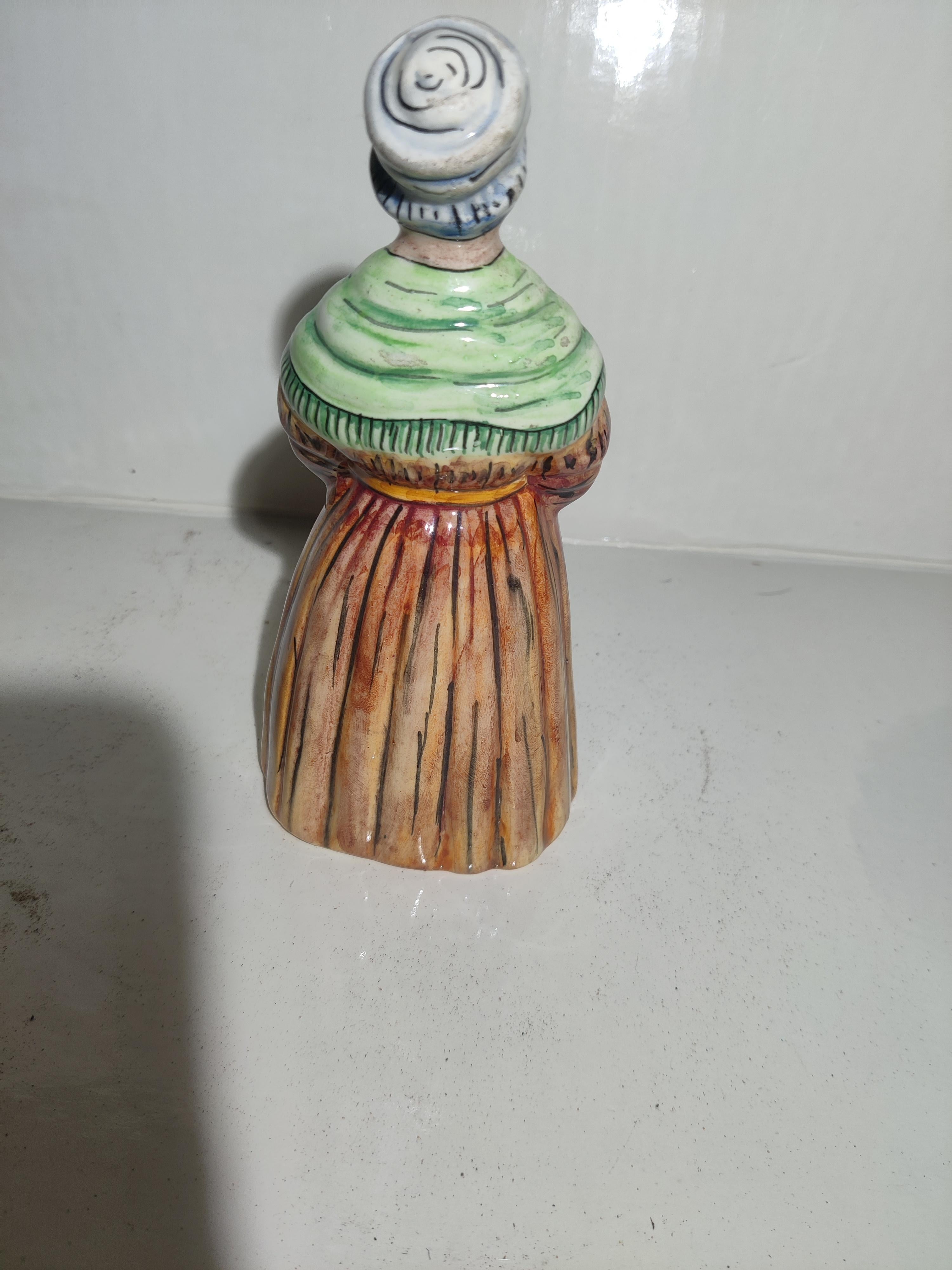 French Faience Majolica Dinner Bell.
Peasant Woman with hands in apron pocket. 
With working clapper.
No chips or other damage. 