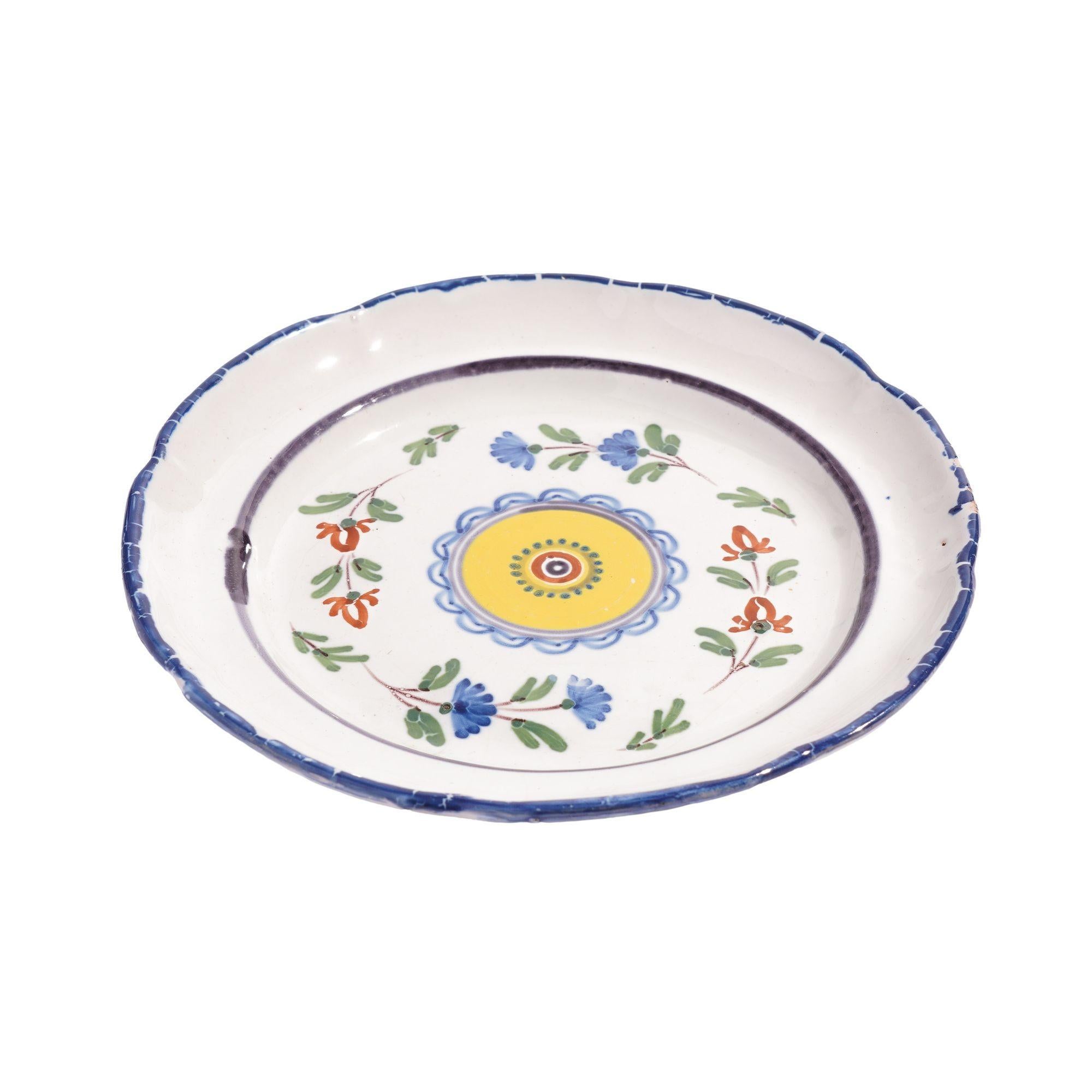 Französischer Fayenceteller mit floralem Muster um einen zentralen hellgelben Kreis.
Frankreich, frühe 1800er Jahre.