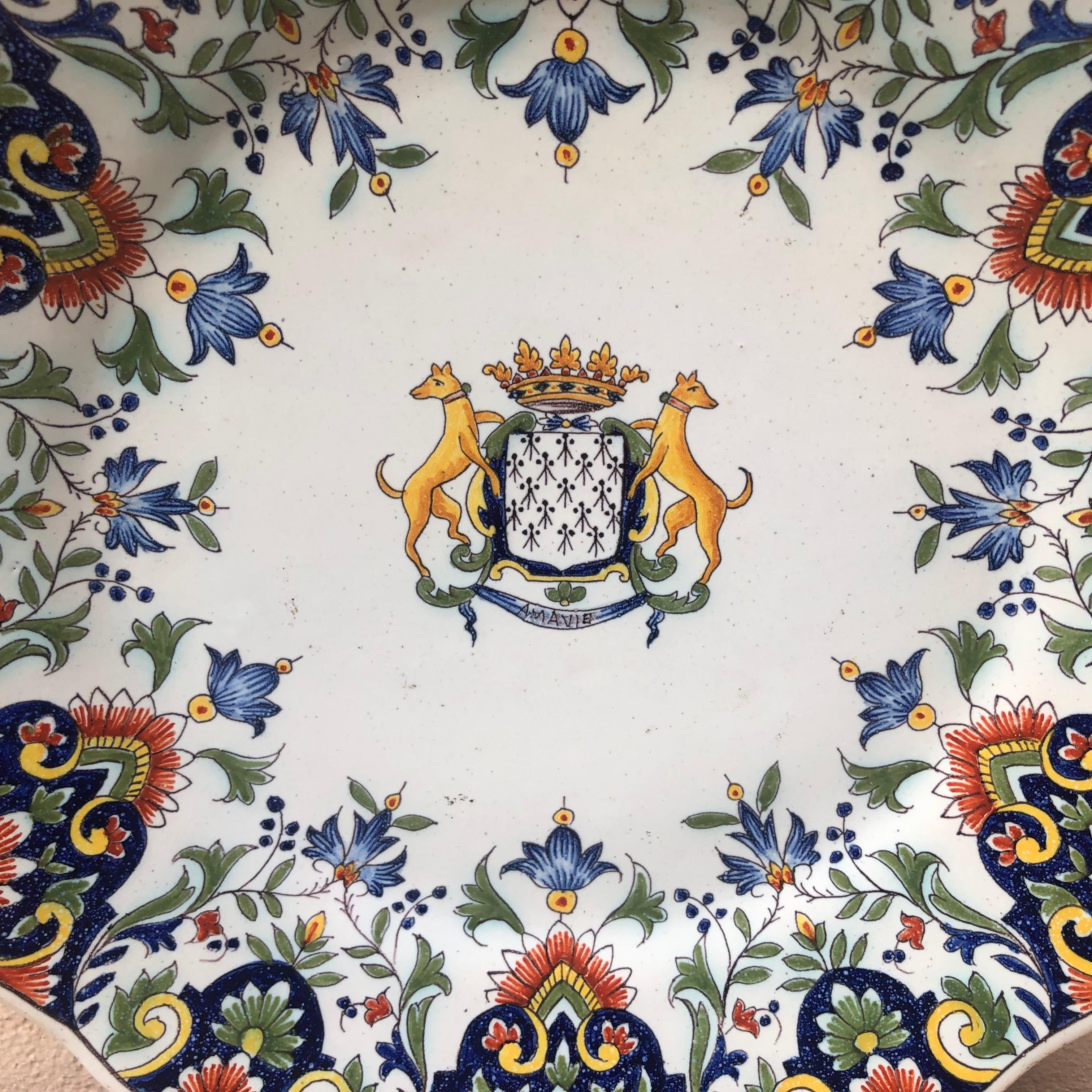A French faience plate with a coat of arms and rich floral border signed Fourmaintraux Desvres, circa 1890.