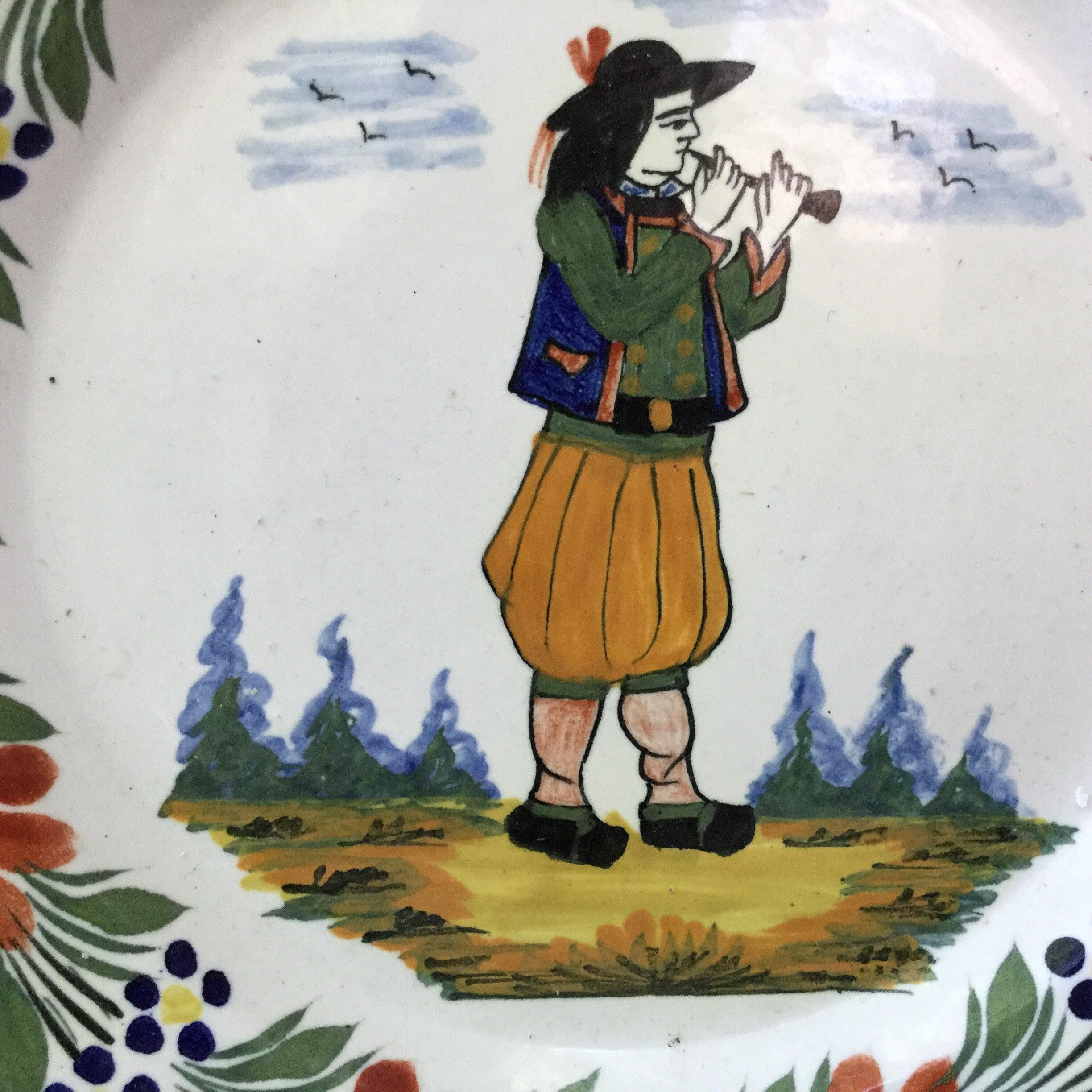 Large French faience plate with a Breton playing music signed Henriot Quimper, circa 1940.