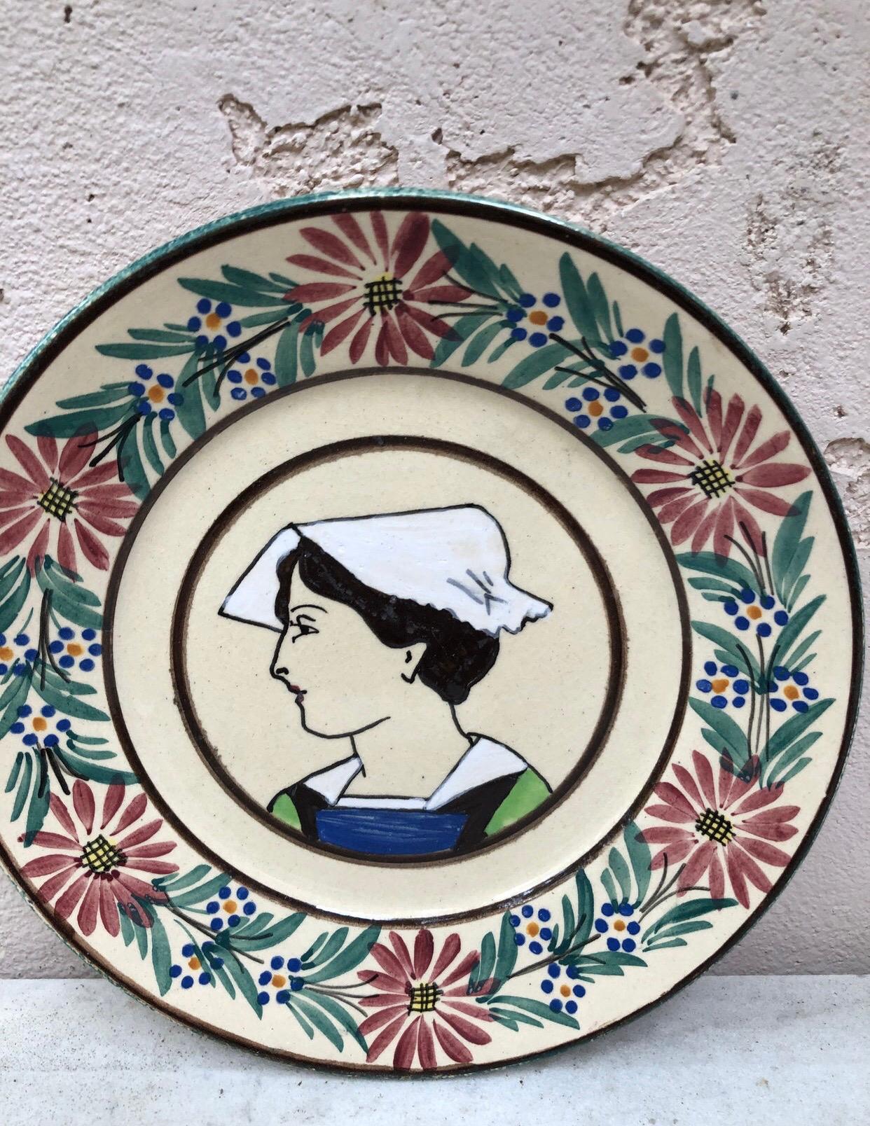Assiette en faïence française Quimper, vers 1920
Bordure avec des fleurs, représentant une femme avec le costume traditionnel de la Bretagne.