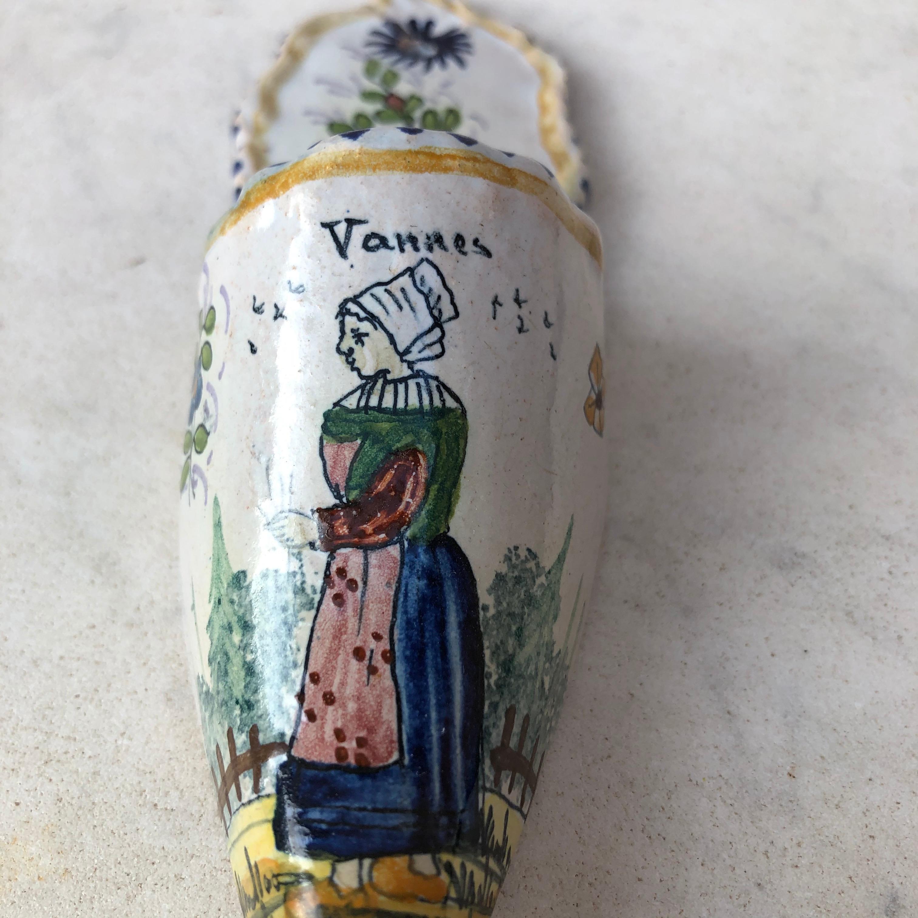 Small French faience shoe wall pocket, circa 1900.
From Brittany signed Vannes in the front.
Hand painted with a farmer from Brittany and flowers.