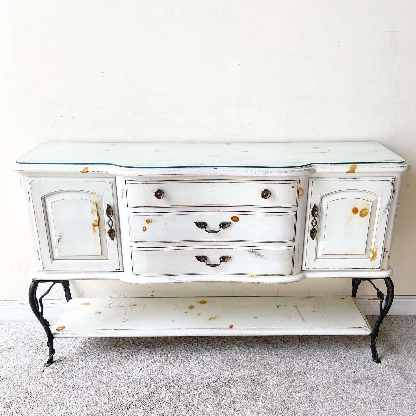 Incredible vintage French farmhouse style wooden credenza. Features a white finish with burnt Burl through the surfaces. The credenza sits on 4 iron legs with a shelf.