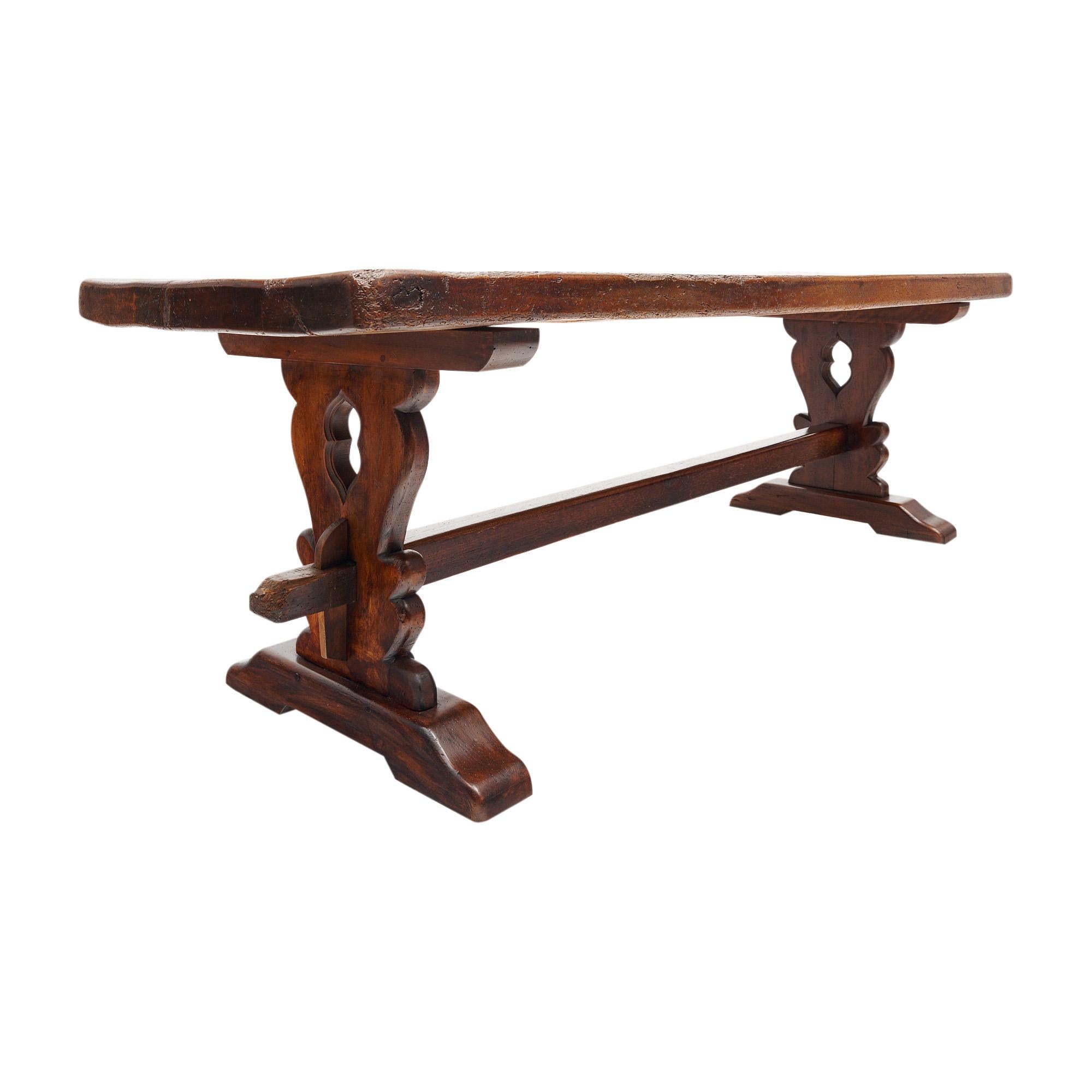 Table de salle à manger française fabriquée en chêne massif et finie avec un poli lustré à la cire. Les deux piédestaux sculptés à la main sont reliés par un châssis. Des clés en bois permettent de verrouiller la base. Cette table peut accueillir 8