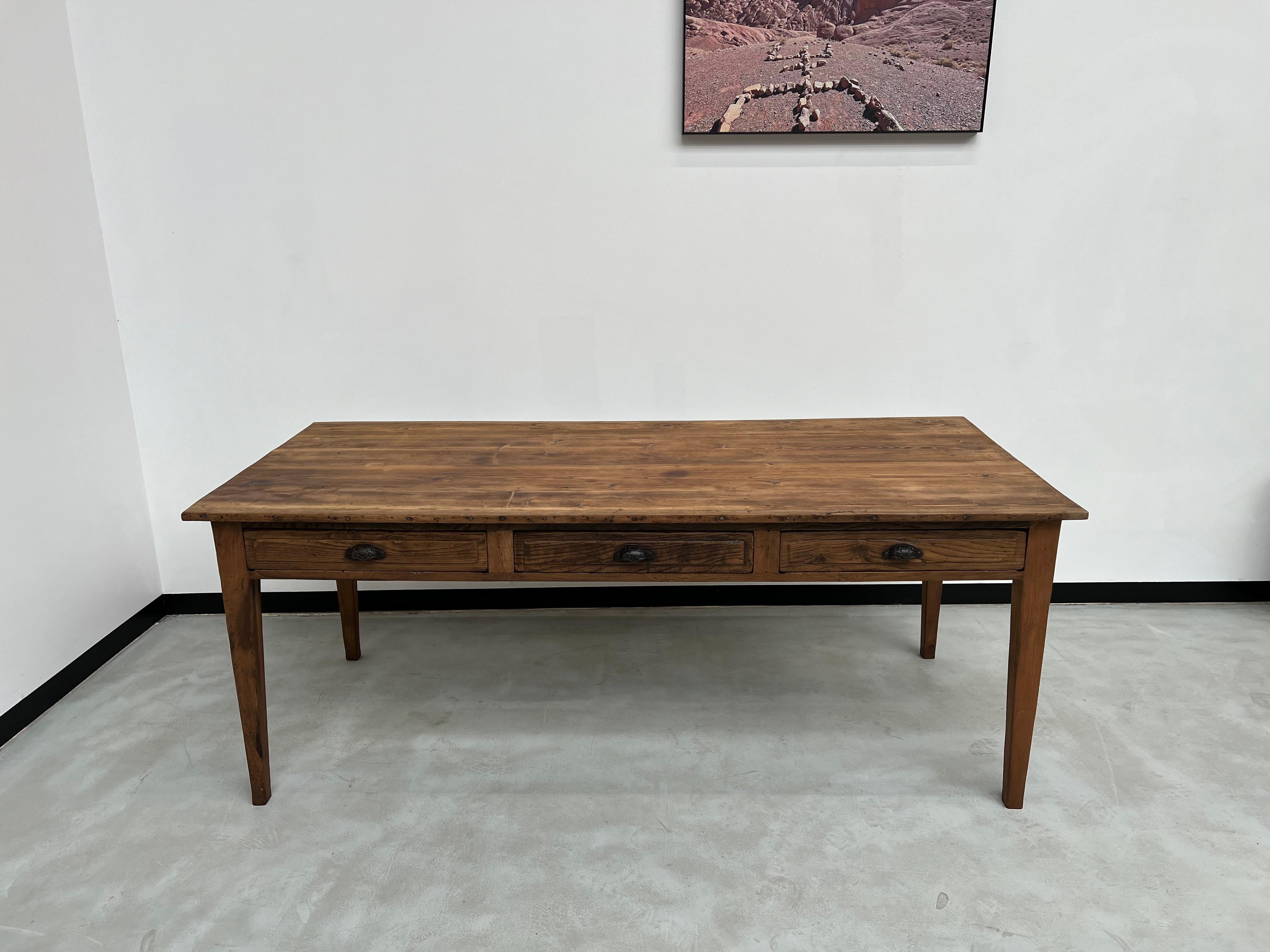 Maison Lecan presents this farm table from the 1950s, entirely restored by us. Its pine top is finished along its lengths with two oak strips to improve the aesthetics. Its legs and drawer fronts are also made of solid oak. The three drawers are