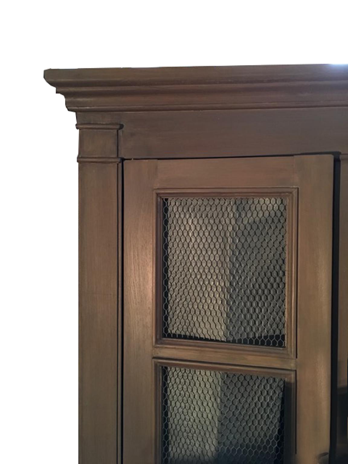 This is a cabinet in French style, typical of the Provence, a country French province, with three doors closed by metal mesh panels, with keys. 

It is a contemporary handmade production in solid oakwood and it is painted in a warm sable color with