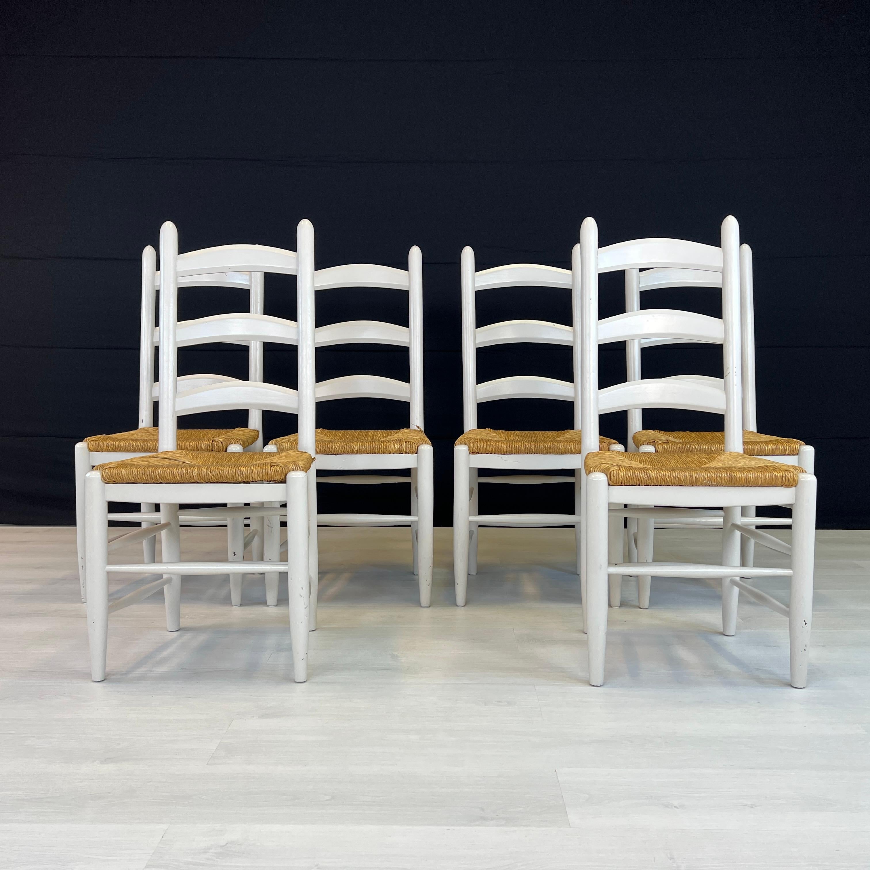 Dimensions: H 41.5” x W 17.5” x SD 15” x SH 18.5”

Set of 6 French Farmhouse oak ladder back dining chairs. Original rush woven seats and white painted legs and frames. Vintage furniture is great for the environment, for your home, and your wallet.