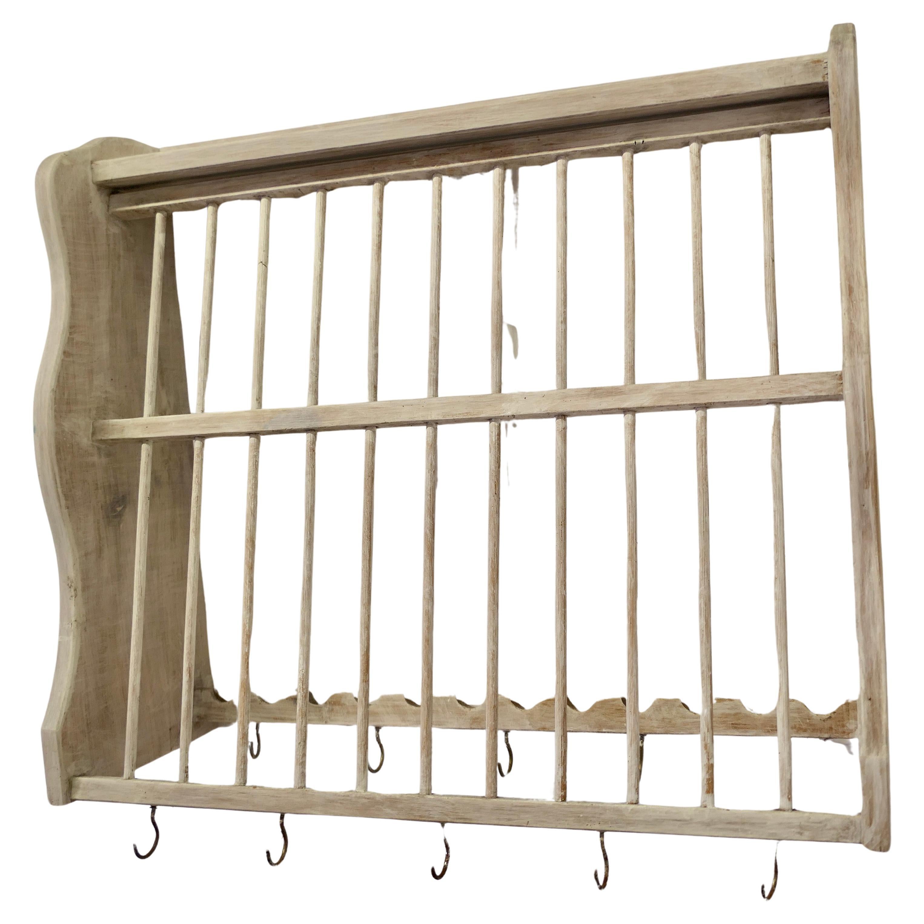 French Farmhouse Pine Plate Rack

This useful piece hangs on the wall and drains and stores plates until required
It is made from pine and allows 2 rows of plates to be stored at any one time, it has 2 rows of cup hooks along the bottom, it has as