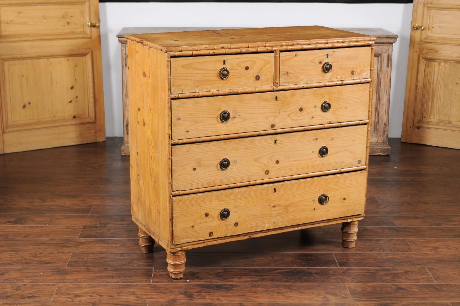 A French faux-bamboo pine chest-of-drawers from the late 19th century, with cylindrical feet. Born in France during the last quarter of the 19th century, this rustic chest features a rectangular top accented with a faux-bamboo trim, sitting above