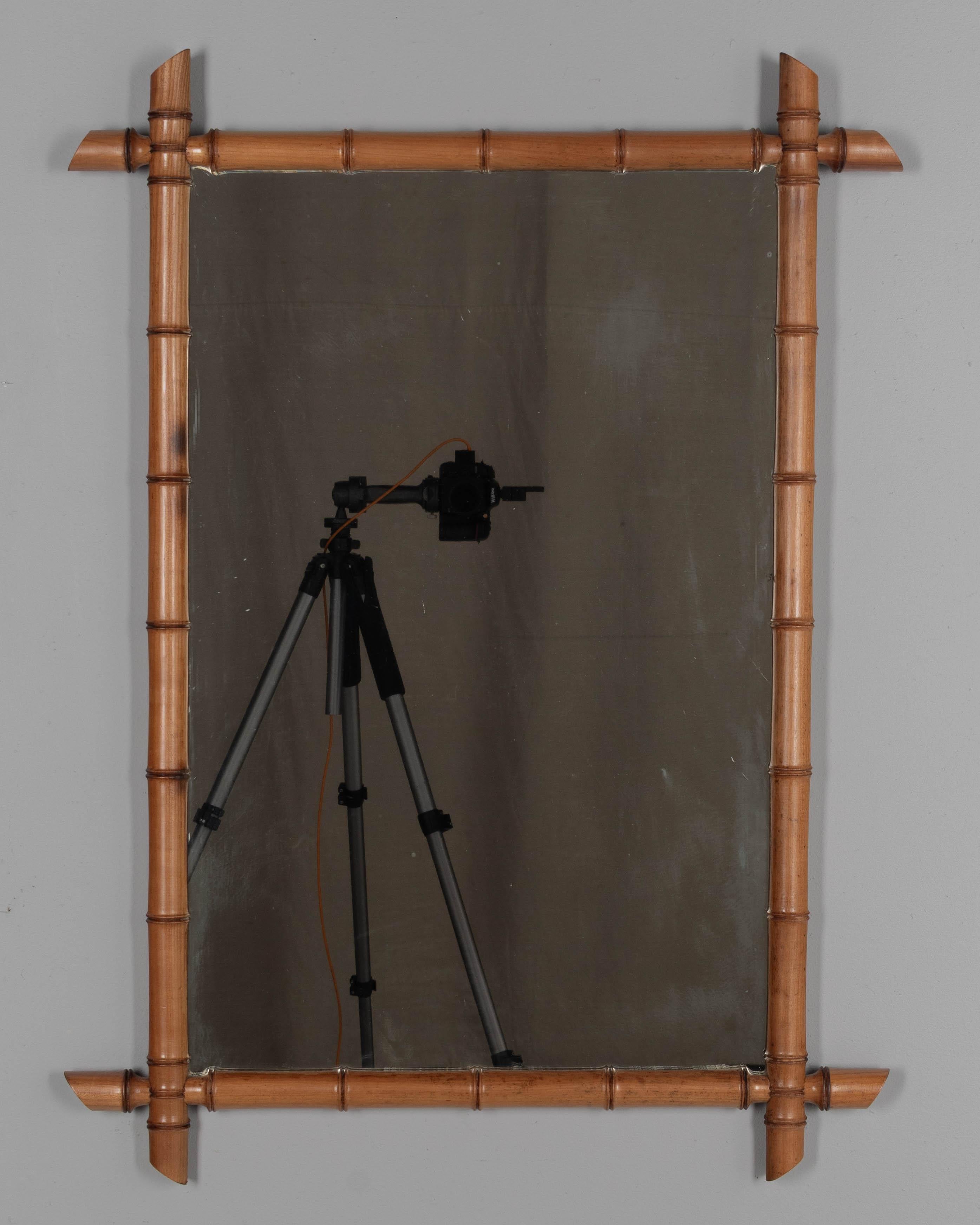 Ein französischer Wandspiegel aus gedrechseltem Kirschbaumholz mit gewachster Patina und Bambusrahmen. Original-Spiegel mit einigen beschlagenen und fleckigen Stellen. CIRCA um 1900.
Äußere Abmessungen: 27,5 