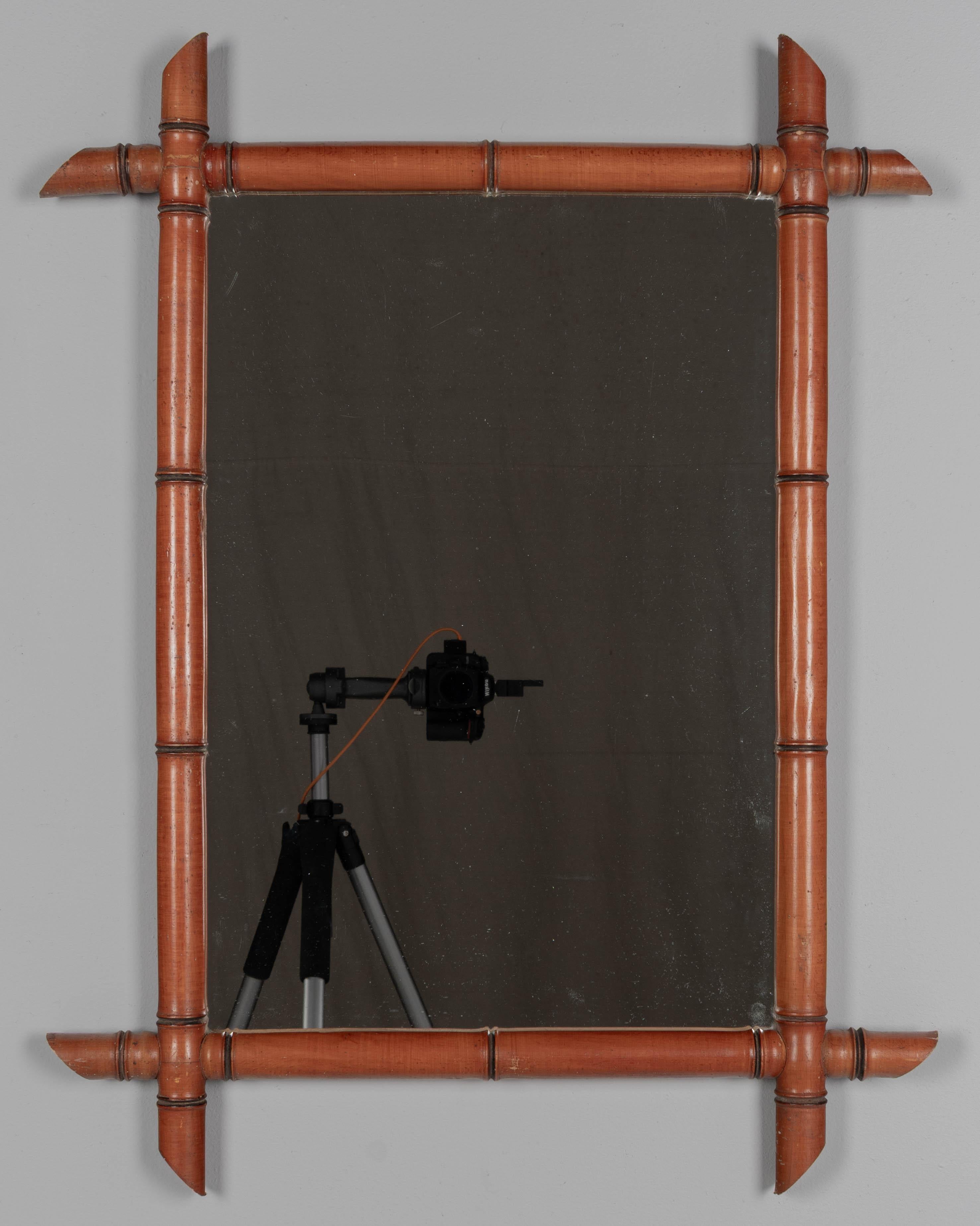 Specchio da parete francese con cornice in finto bambù, realizzato in legno di ciliegio tornito con patina cerata. Specchio originale circa anni '50.
Dimensioni esterne: 26,5