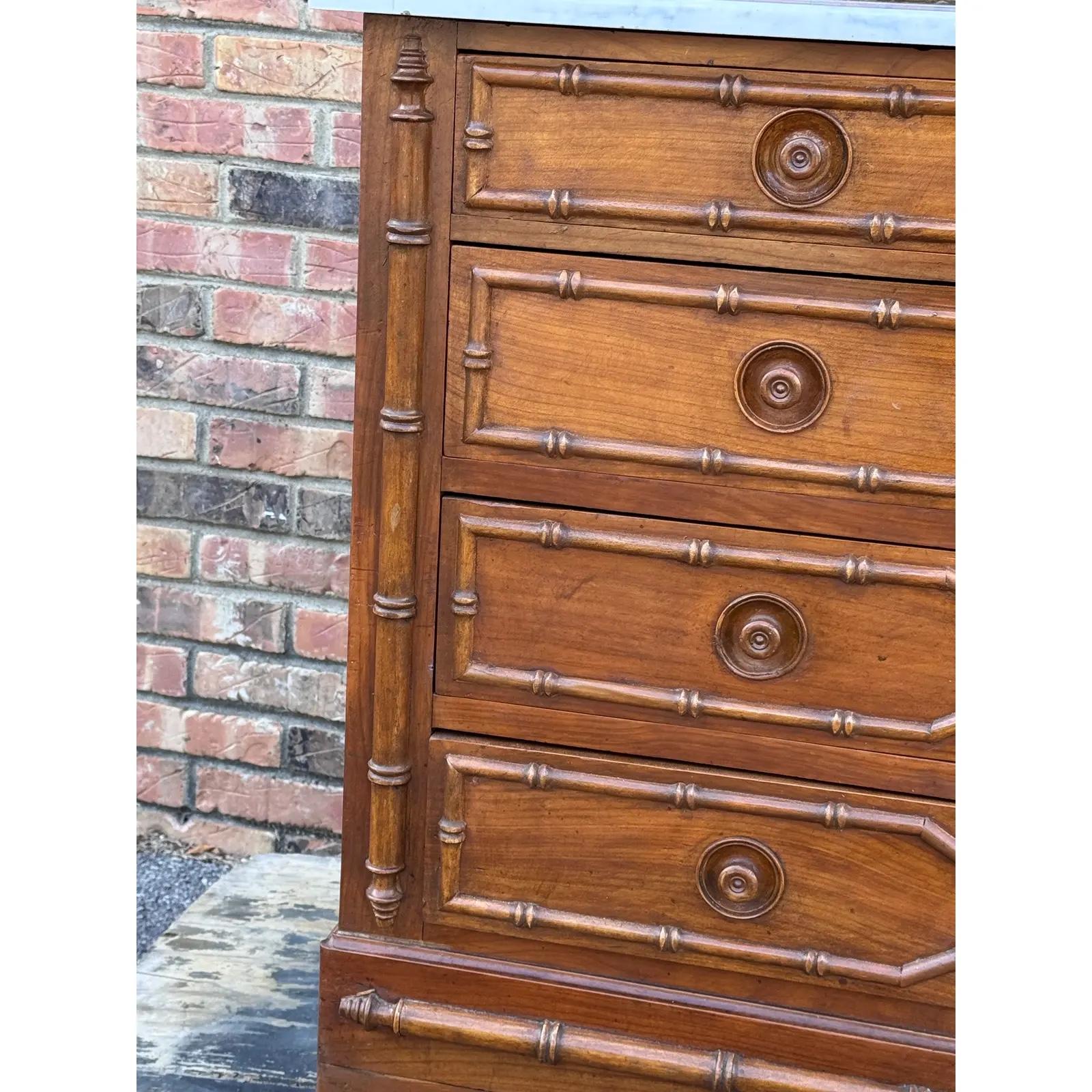 This 19th-century faux bamboo chest with a white marble top is a captivating blend of sophistication and charm. The intricate faux bamboo detailing adds a touch of timeless allure, while the pristine white marble top exudes a sense of refined