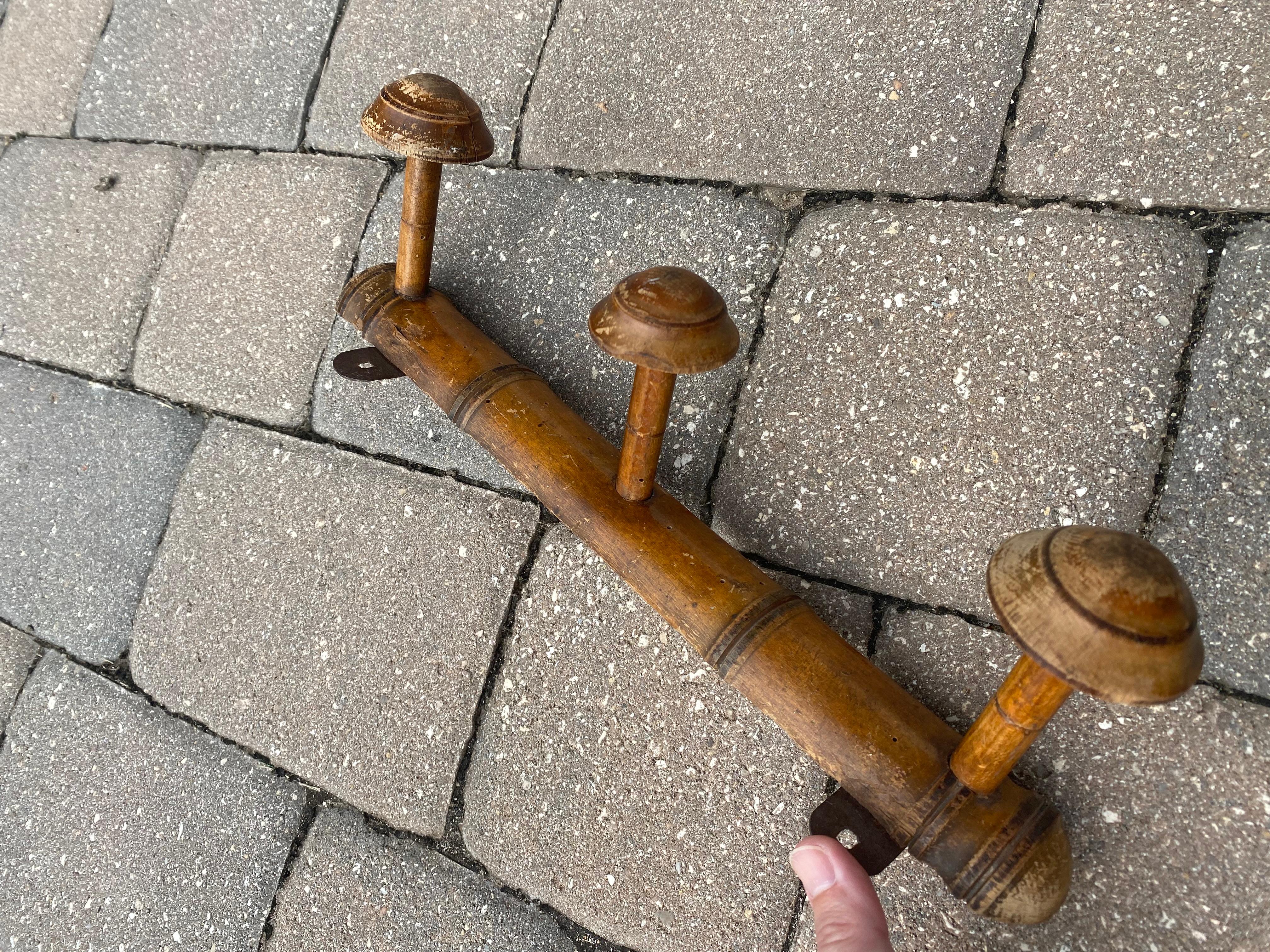French Faux Bamboo coat or purse rack, this piece is the perfect combination of utility and beauty. Crafted from warm, natural wood, it features three generously sized, rounded pegs that offer ample space for coats, hats, or accessories. The piece