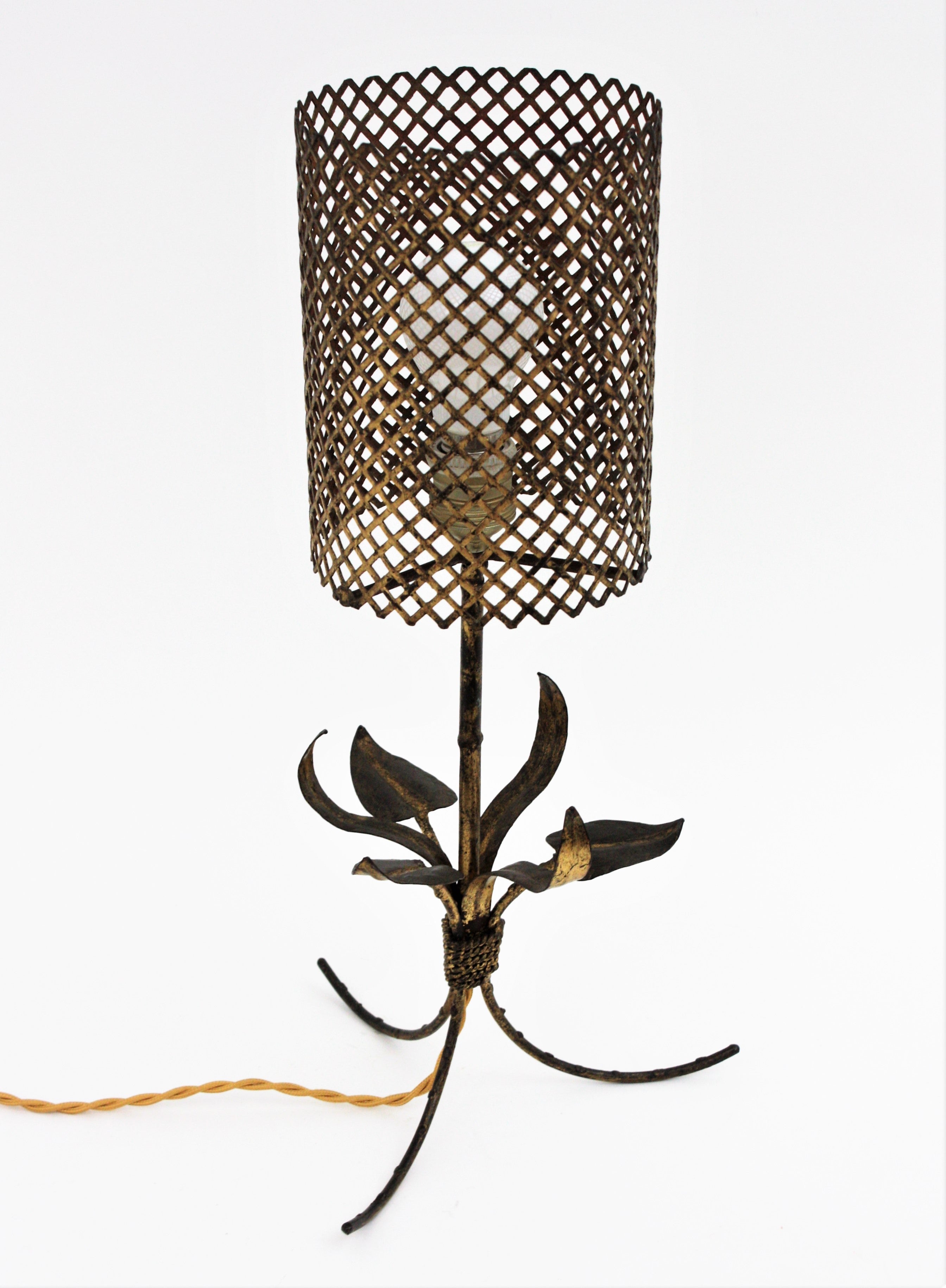 An elegant foliage faux bamboo tripod table lamp with iron wire cylinder lampshade, Gilt Iron, France, 1940s.
This beautiful Maison Baguès inspired faux bamboo table lamp features a bouquet of leaves on the base tied by a twisted iron rope. The