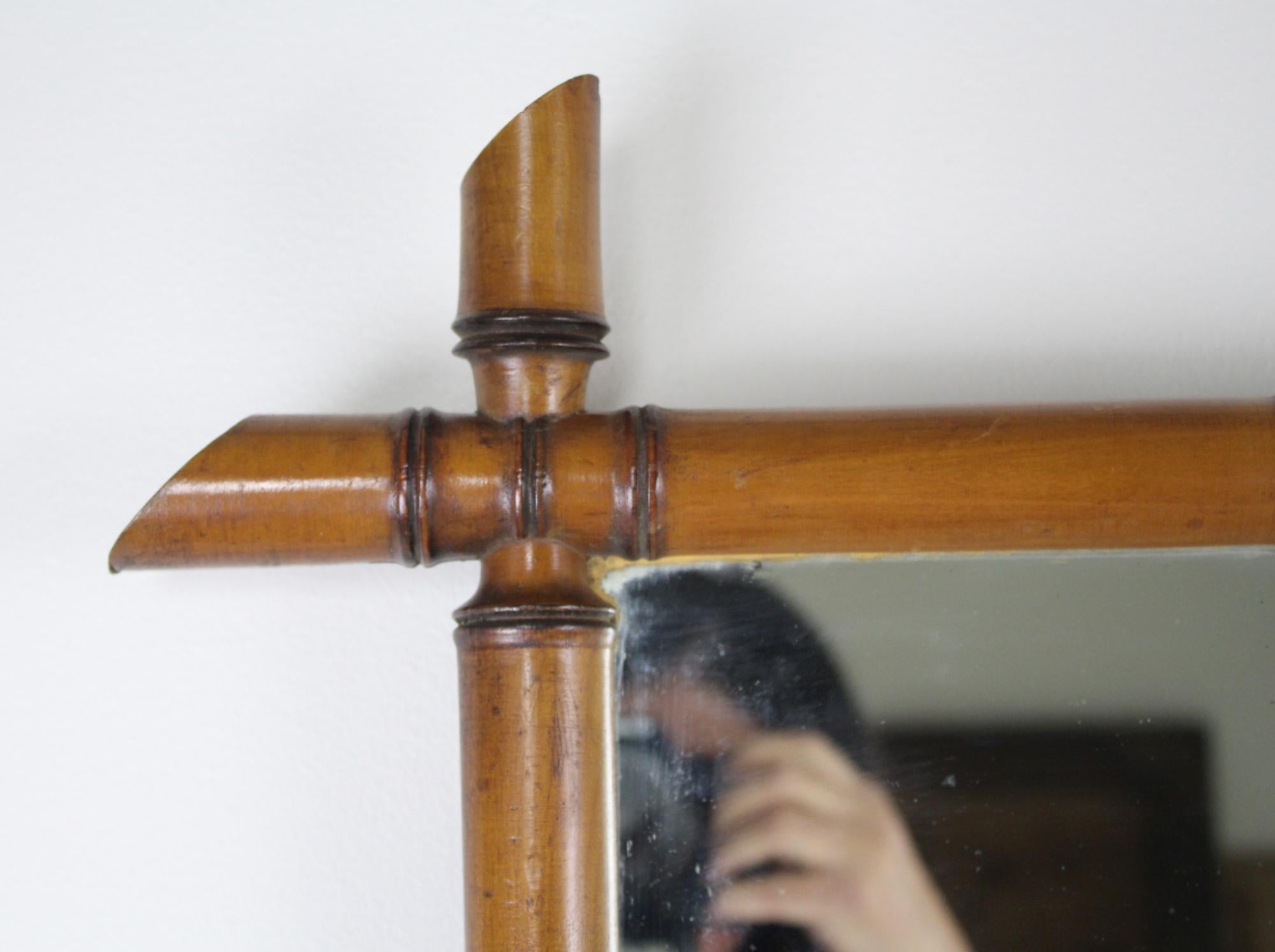 Our French faux-bamboo mirror features a simple yet elegant silhouette, adorned with a honey-colored frame. Each side intersects and crosses the path of the other one. The original glass has some minor wear in the corner, as shown in image #6.