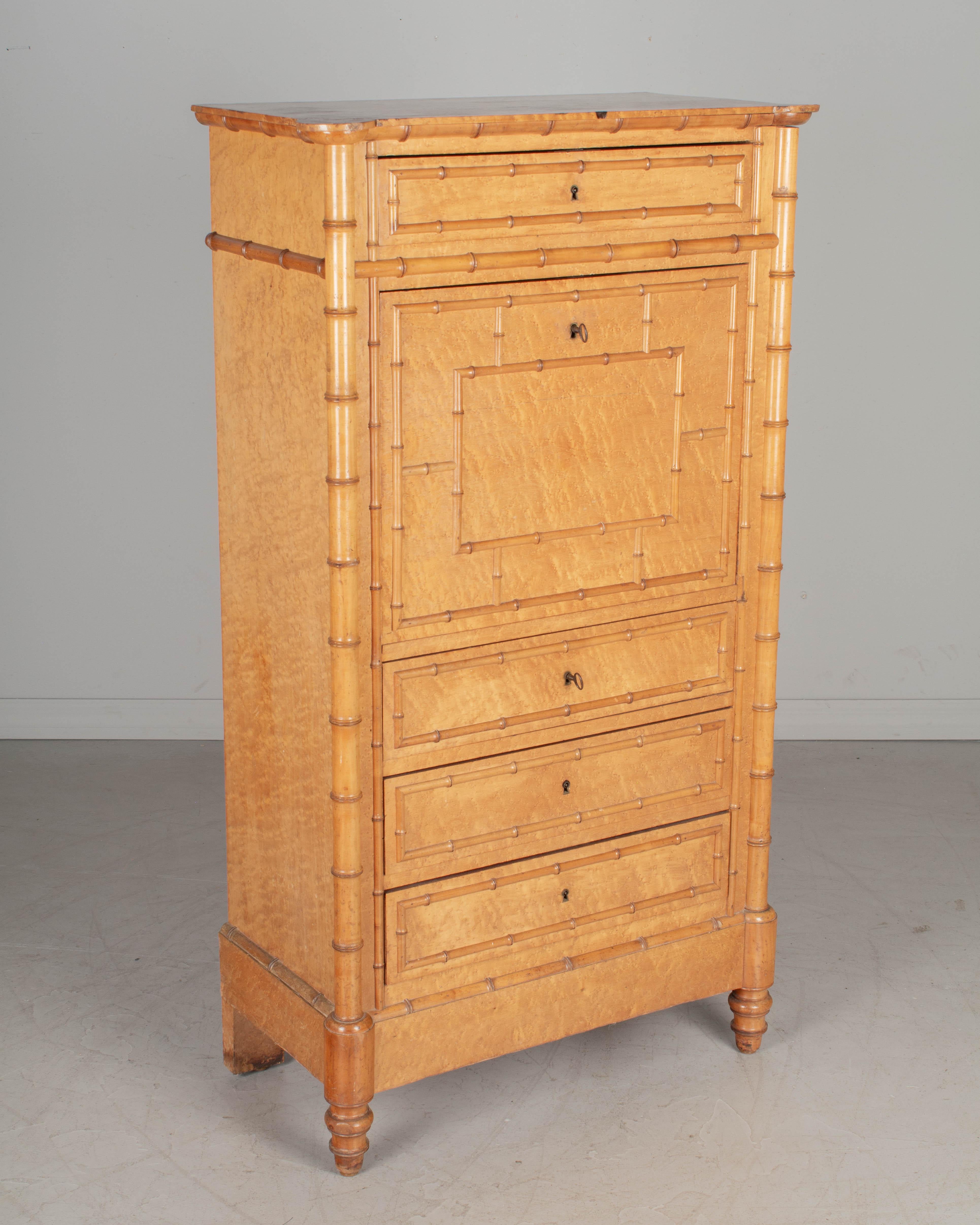 A French secrétaire à abattant, or drop front secretary desk, with the case made of birdseye maple veneer over solid oak and the faux bamboo details made of turned cherry wood. Four dovetailed drawers with working locks and two keys. Interior has