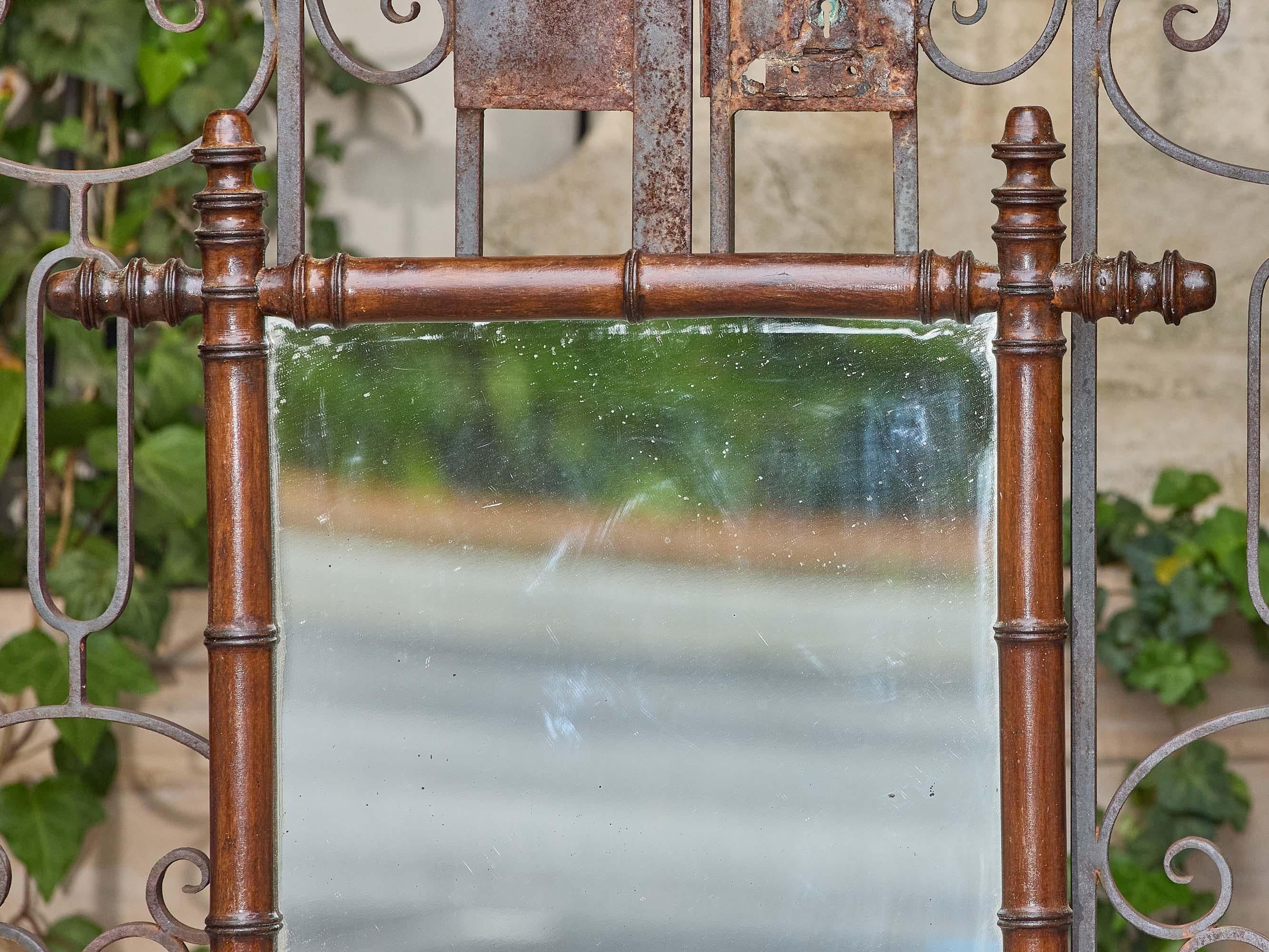 Questo specchio francese in finto bambù, risalente al 1900 circa, trasmette il calore e il fascino delle decorazioni in legno della fine del XIX secolo. La struttura è realizzata in legno duro tinto di scuro, lavorato per imitare il bambù con nodi