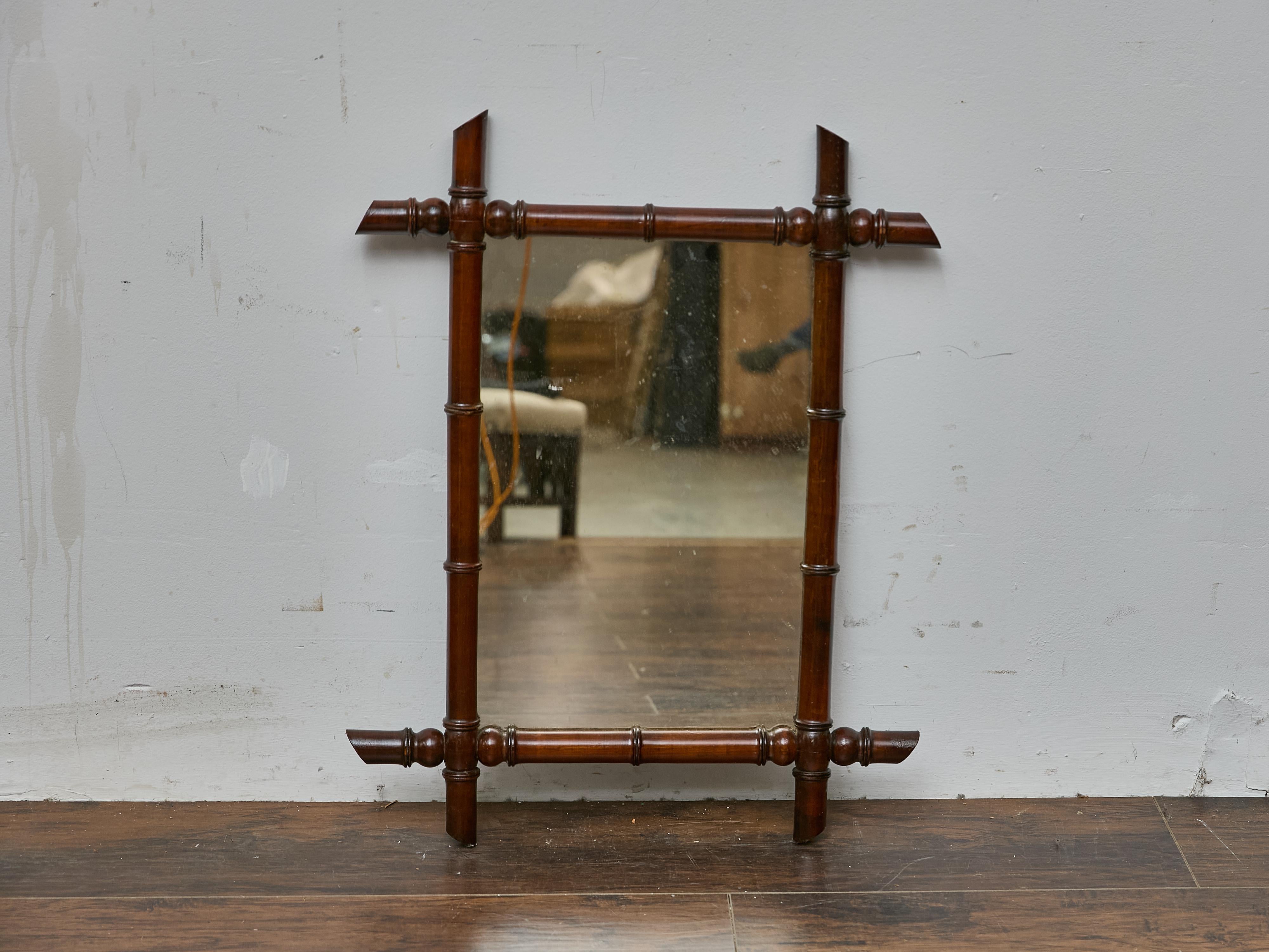Charmant miroir en faux bambou et noyer, fabriqué en France vers 1900. Cette pièce présente les proportions fines et la légèreté visuelle associées au faux bambou français de la fin du XIXe siècle et du début du XXe siècle. Le cadre tourné imite le