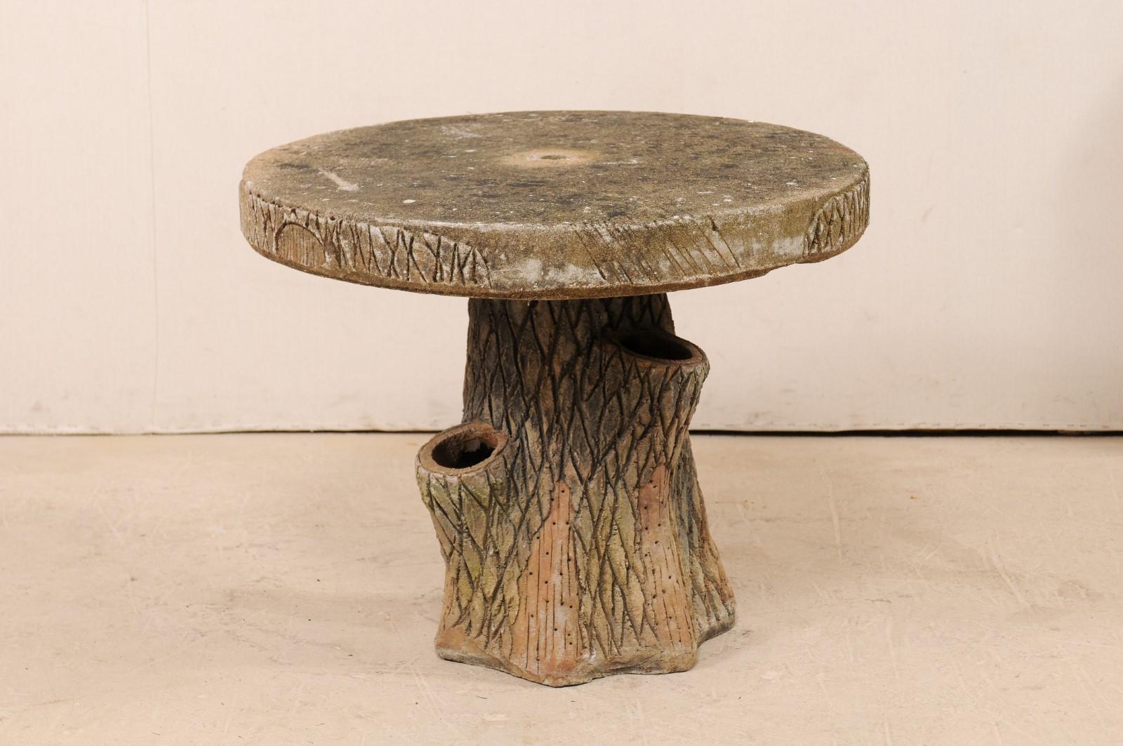 A vintage French faux bois outdoor garden or patio table. This patio table from France has been designed in faux bois fashion, lending it's appearance to resemble that of a tree; the round top a thickly sliced slab, while the base being that of a