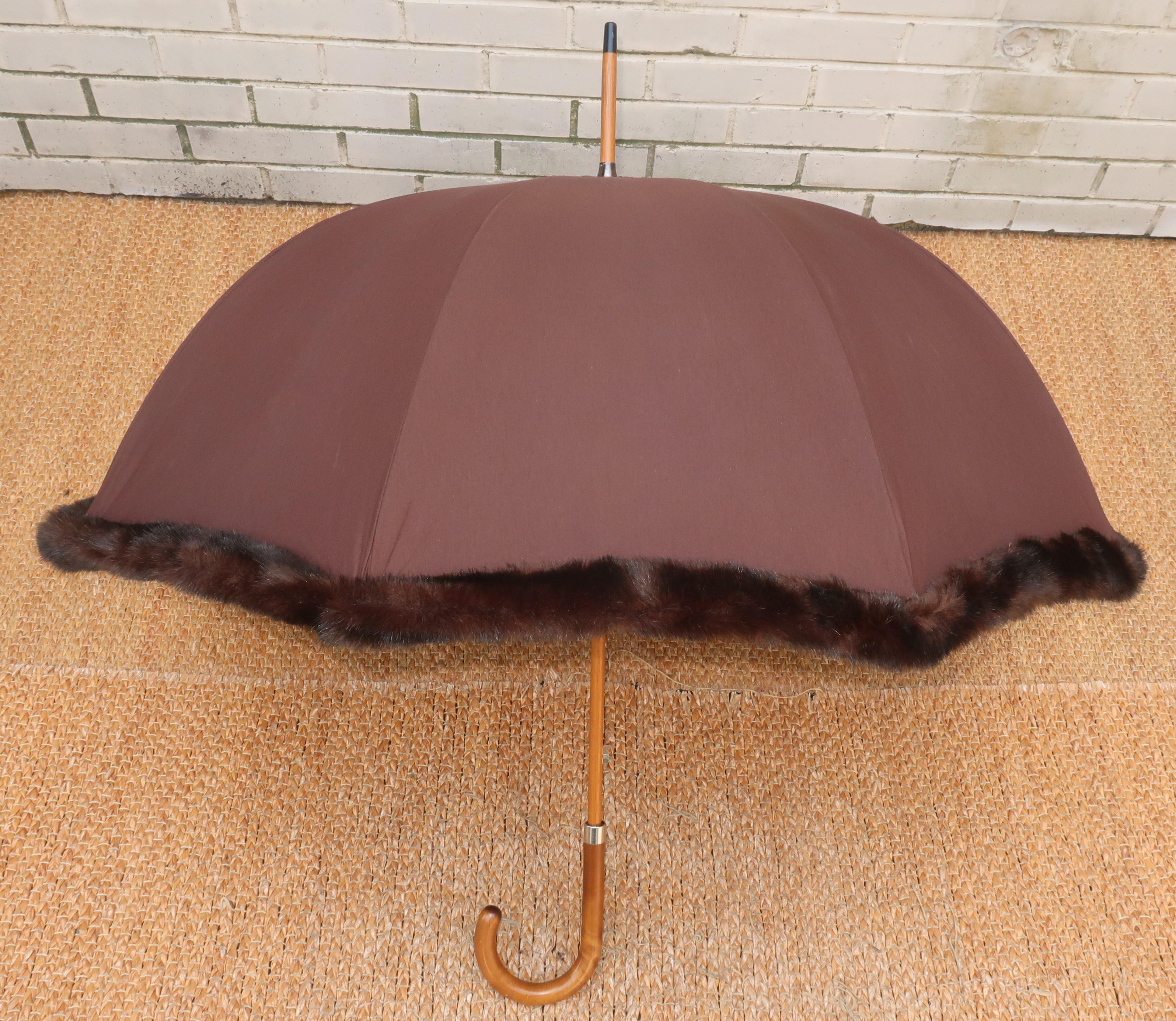Faux fabulous!  The ultimate in glam and sophistication ... a faux fur trimmed brown umbrella with wooden handle and size enough to cover two.  The canopy of the umbrella is made with a polyester cotton blend also making it the perfect accessory for
