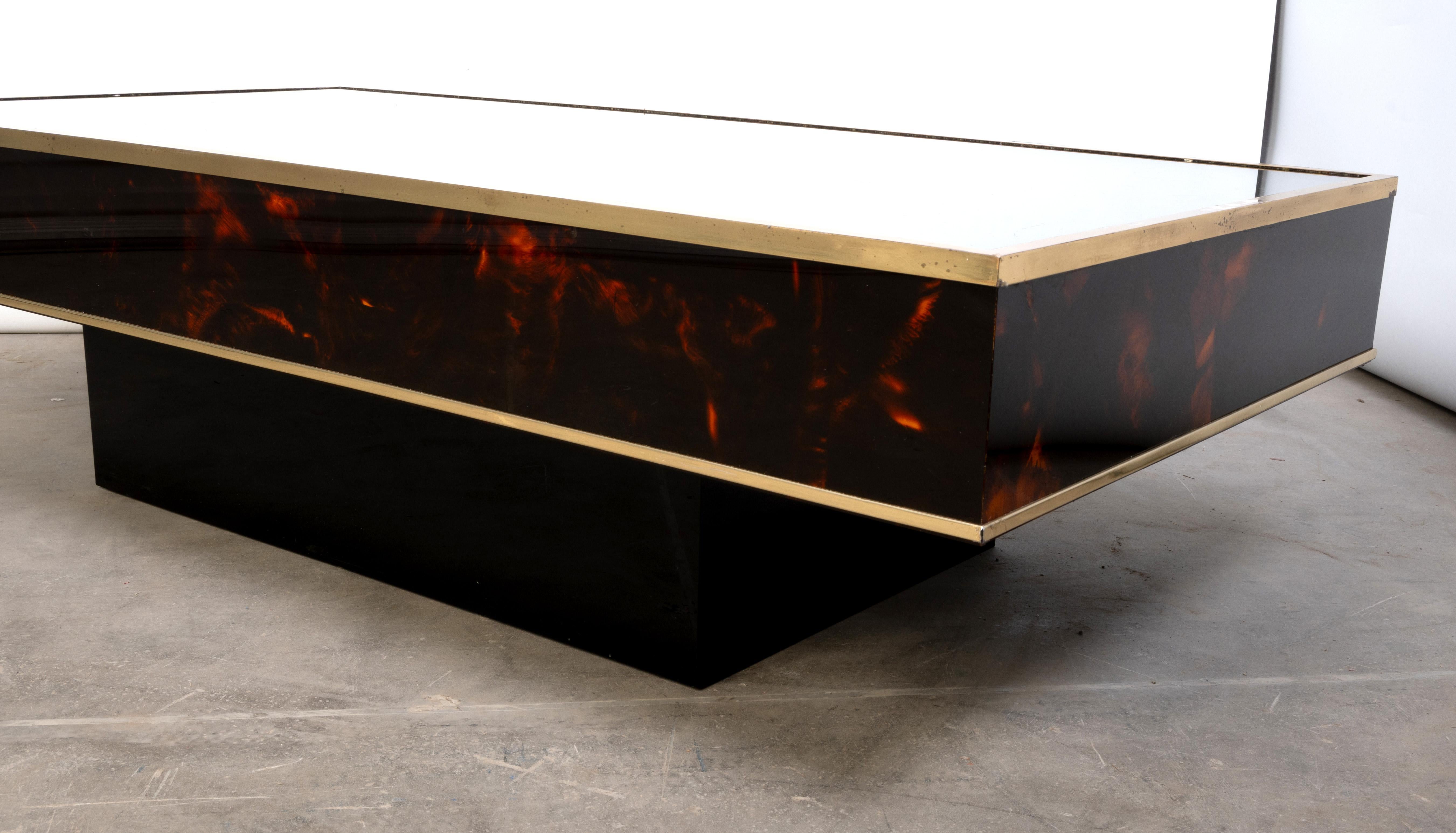 French Faux Tortoise Shell Lacquer & Brass Coffee Table 

Designed by Eric Maville and Jean Claude Mahey for Maison Romeo C.1970

A lacquered coffee table, with gilt edges, raised on a black rectangular block base, makers plaque to the side.

Known