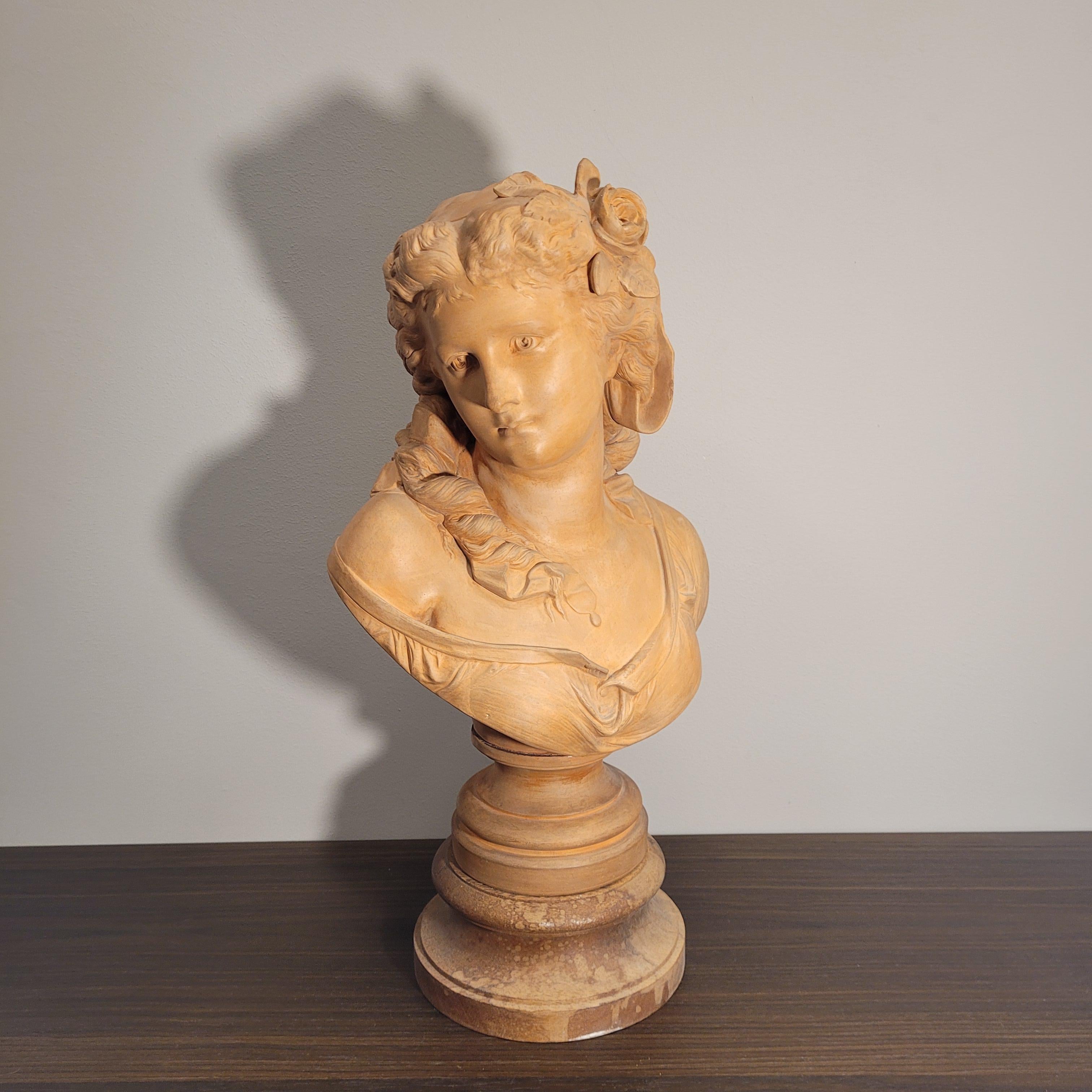 One of a kind  female bust in terracotta, signed A. Carrier on the back. Seated on a wooden base we find this delicate bust of a young woman, with sweet and delicate features. With her face turned to one side of her, the softness of her complexion
