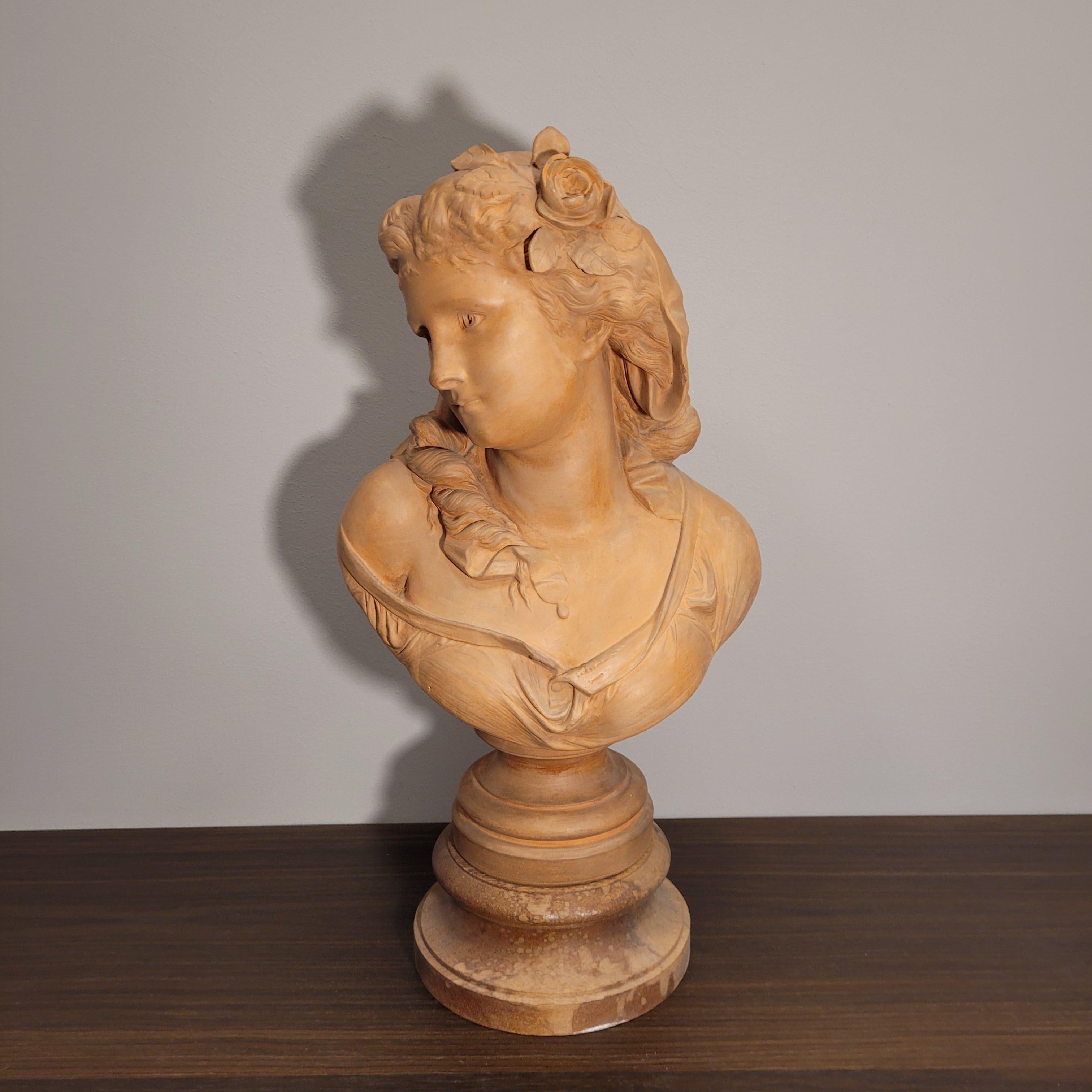 Gorgeous  female bust in terracotta, signed A. Carrier on the back. Seated on a wooden base we find this delicate bust of a young woman, with sweet and delicate features. With her face turned to one side of her, the softness of her complexion stands