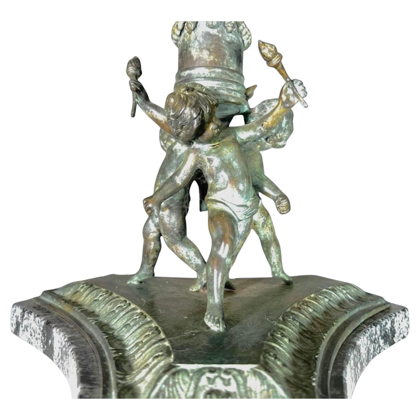 Tavolo Gueridon in bronzo e marmo del XIX secolo, che combina magistralmente scultura in bronzo e marmo pregiato. Il tavolo presenta un piano circolare in marmo nero con venature naturali e bordo lucido, appoggiato su un piedistallo in bronzo