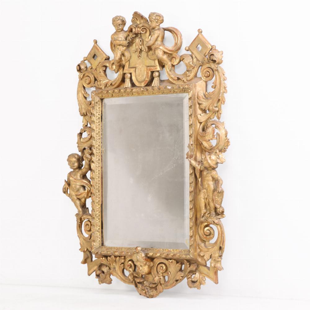 Exquis miroir français en bois doré, vers 1860, sculpté de figures complexes dans le style néo-rococo. Le cadre richement détaillé est orné de rinceaux, de motifs floraux et de multiples figures sculptées.

Le miroir a une présence imposante mais