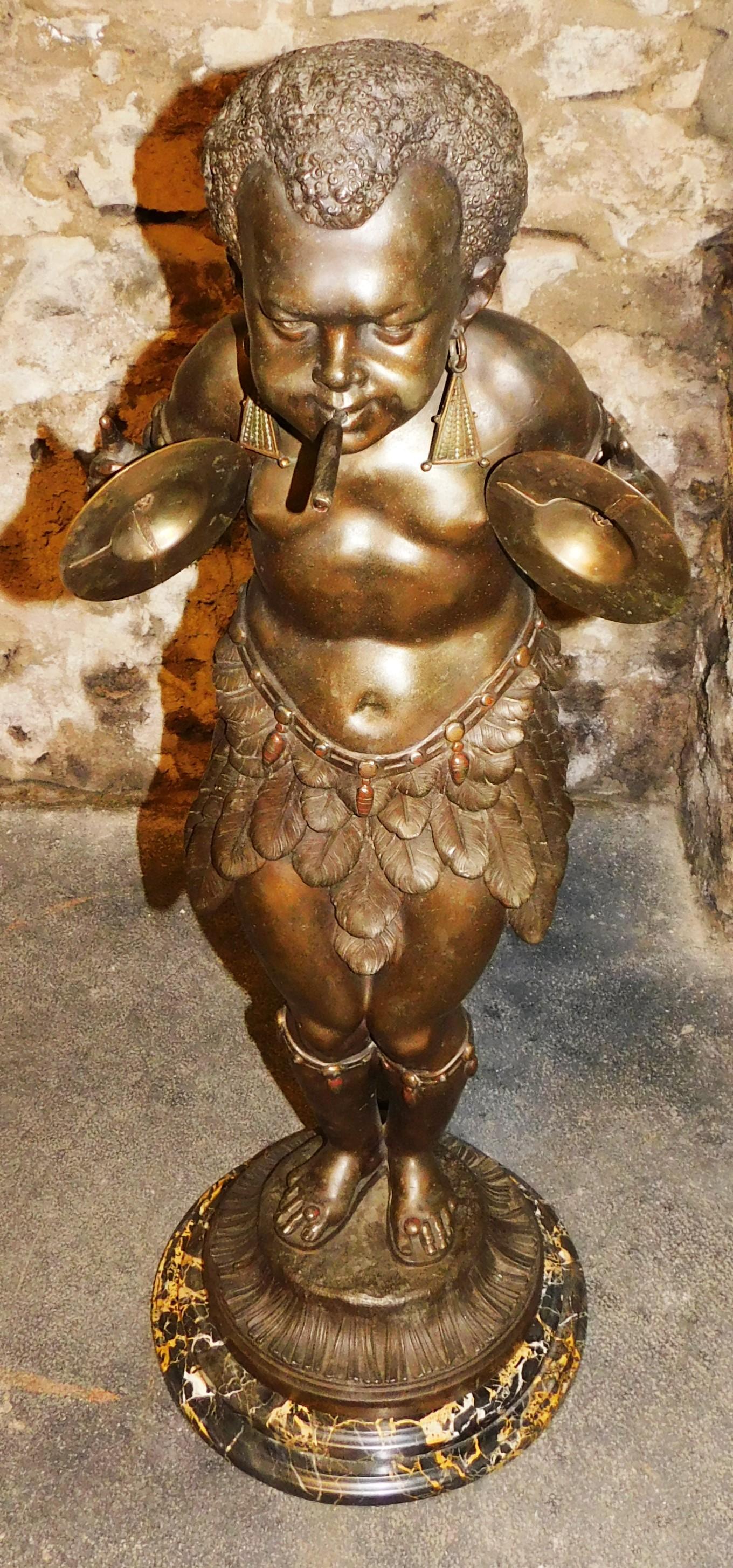 Made in Paris France, antique 19th century bronze African Pygmy playing cymbals with a cigar in mouth. The cigar can be lit with gas, the gas valve fitting on the back is in working condition it will turn on and off. The marble base has been added