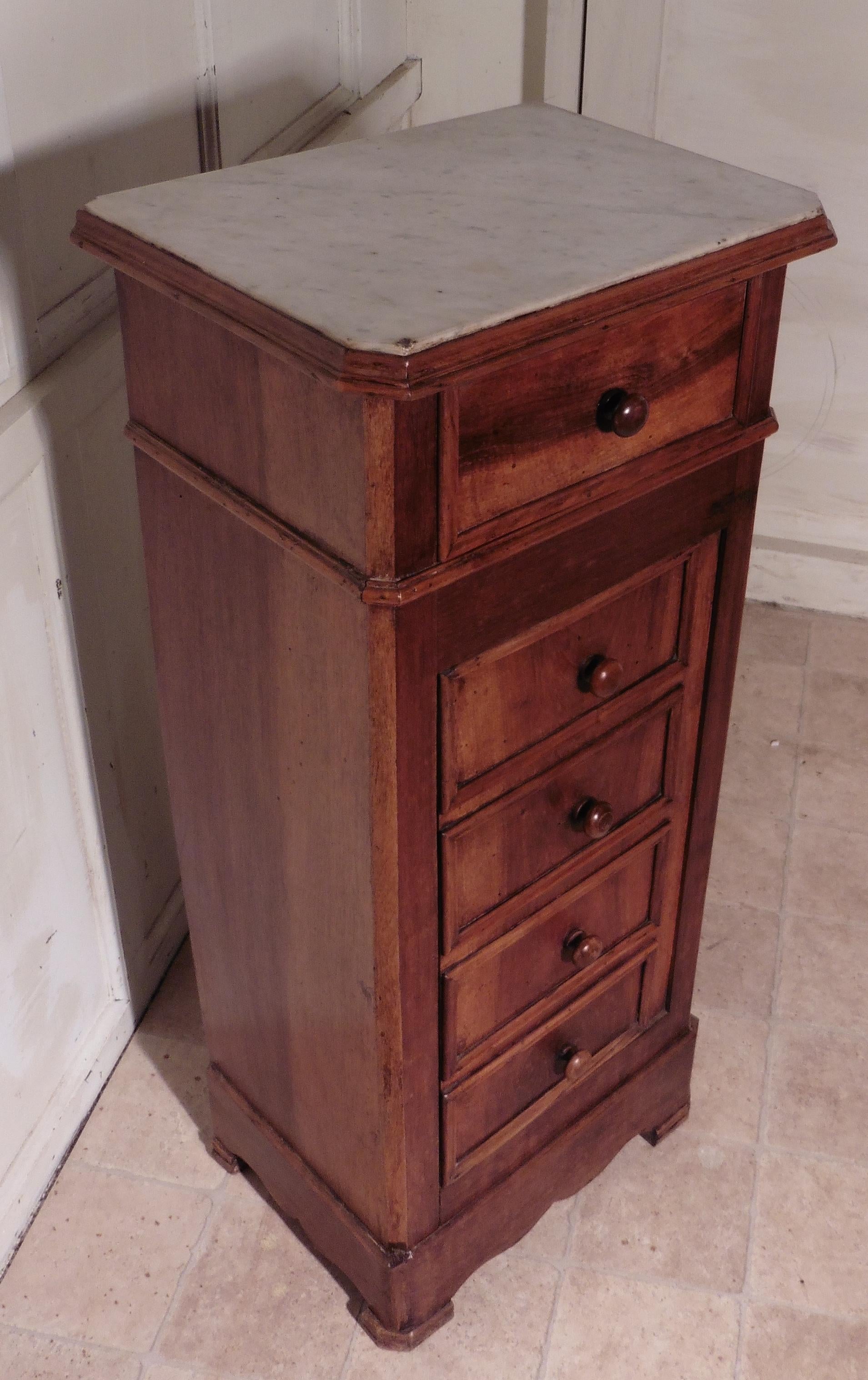 French figured walnut bedside cupboard or night table

 This piece is made from beautifully figured veneers, it appears to have 5 drawers to the front, but the 4 lower drawer fronts are in fact a cupboard door enclosing a shelved cupboard inside,