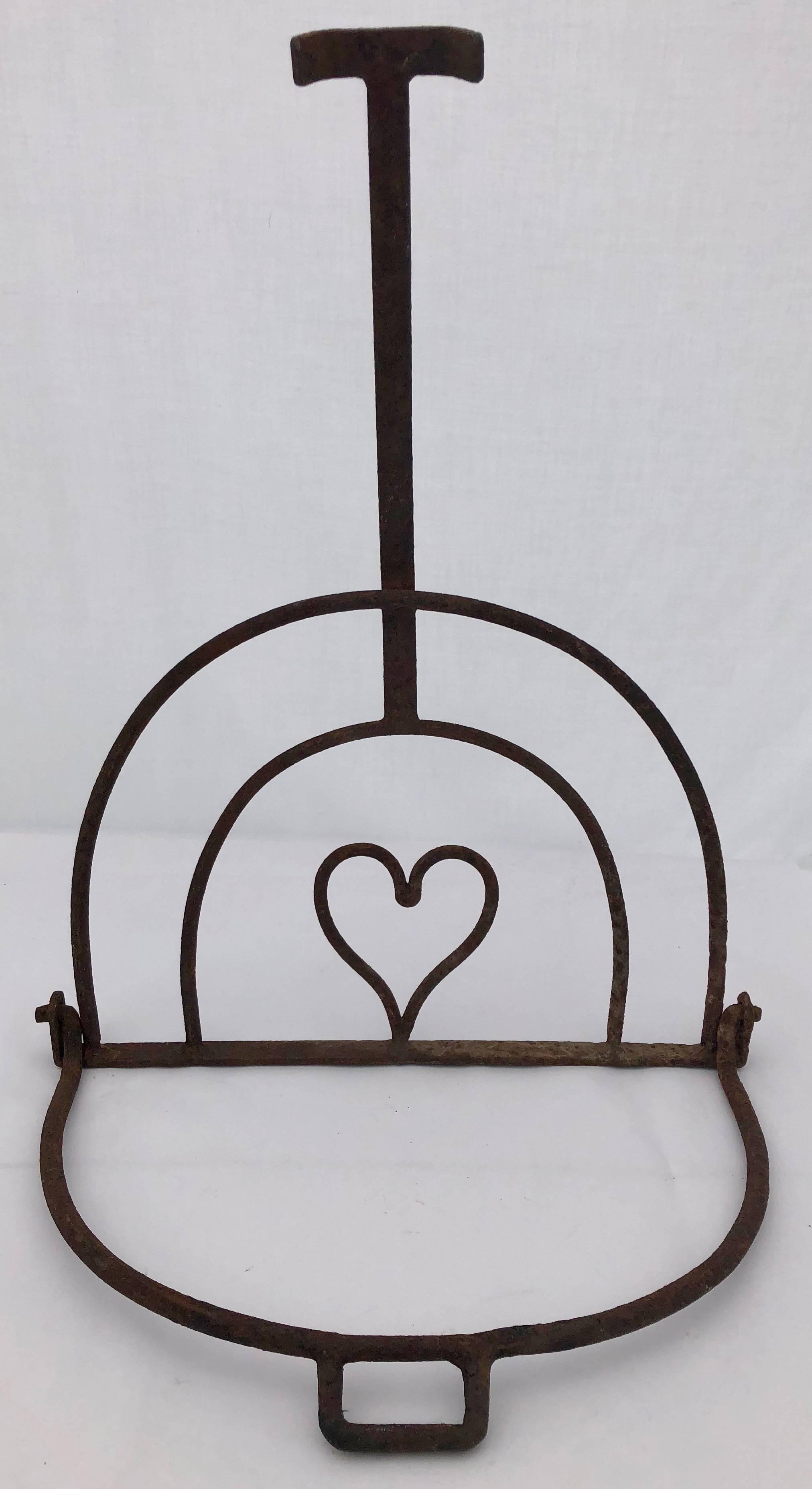 This is a lovely French fireplace forged iron pot holder with a charming heart at its center. It is from the 1800s and would add such charm hanging by a fireplace or displayed on any wall as a beautiful French hand-forged decoration. It is truly a