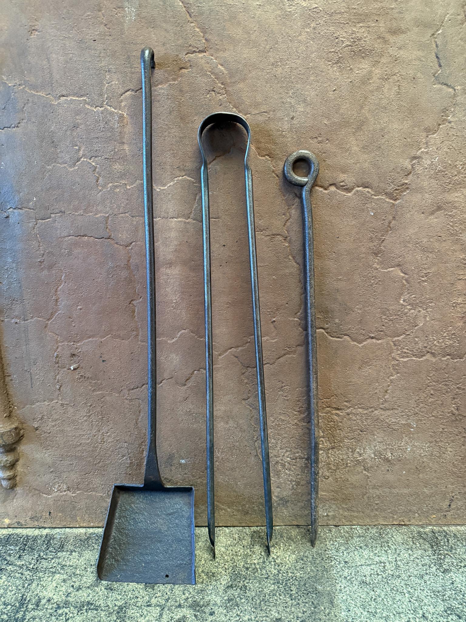 Set di attrezzi da camino francesi forgiati a mano dell'inizio del XVIII secolo. Il set di attrezzi è composto da pinze, pala e attizzatoio. Gli strumenti sono realizzati in ferro battuto. Il set è in buone condizioni e adatto all'uso nel camino. 