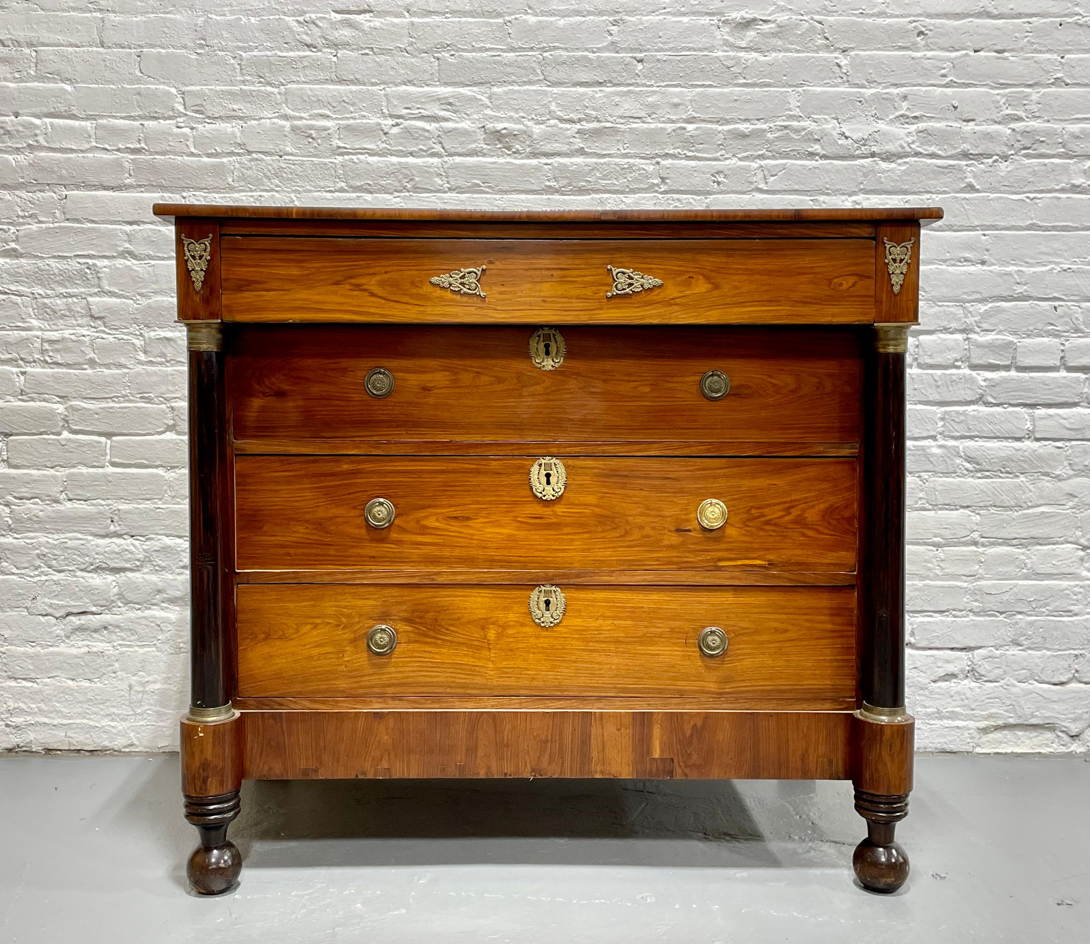 Classic French Empire Chest made from rosewood veneer and featuring ebonized front columns, c. 1810. Iconic of the Empire style, two ebony black round columns flank the bank of dovetailed drawers. The whole stands on sturdy round turned feet and is