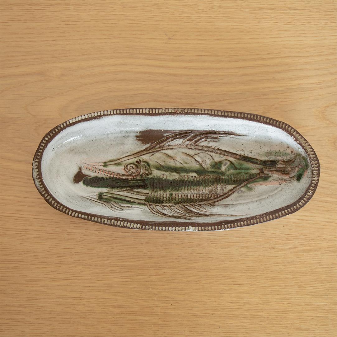 Long ceramic dish by French artist Albert Thiry from the 1970's. White and green glaze with etched fish motif. Signed. 

