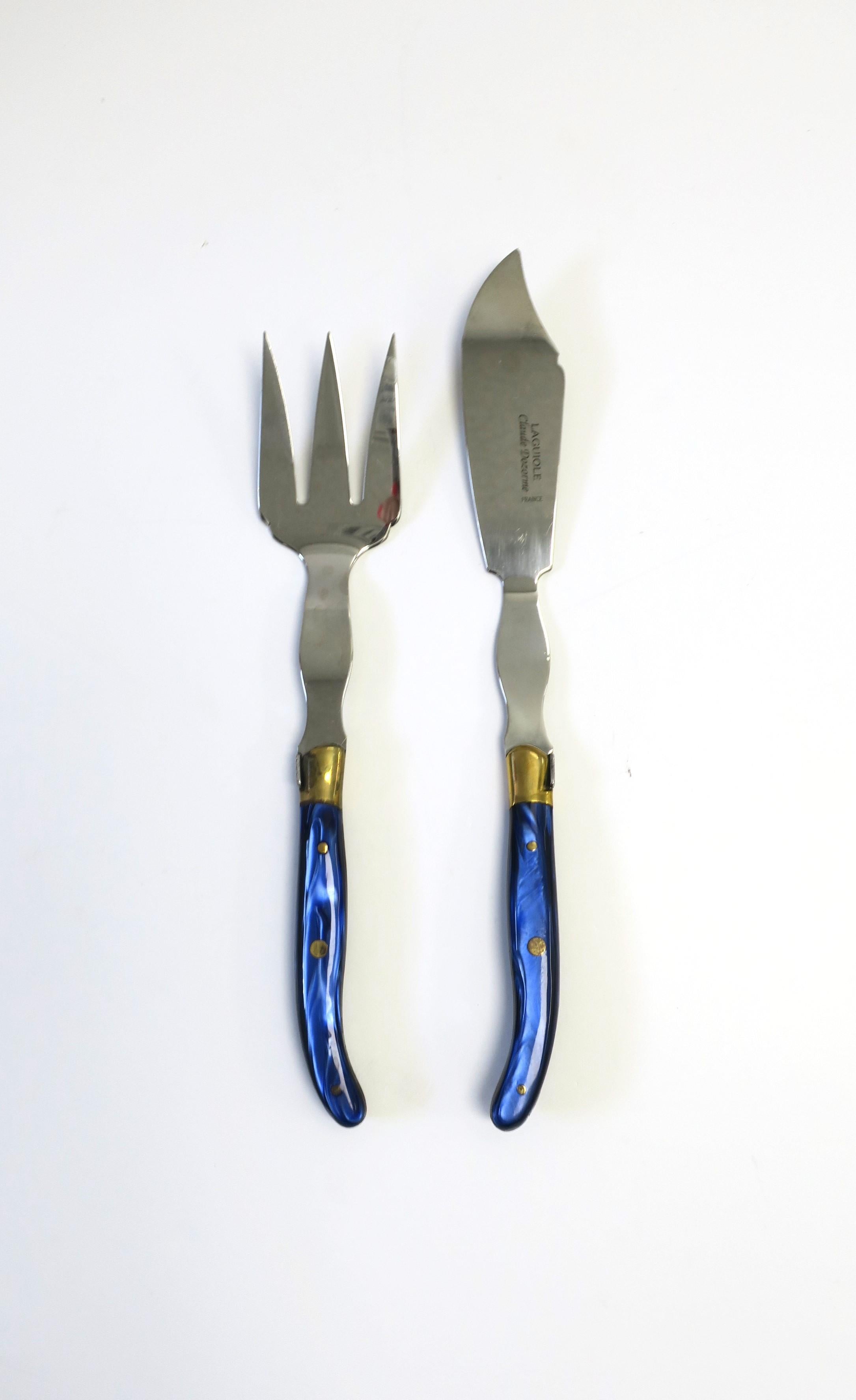 A well-made French fish poisson fork and knife cutlery service set and serving pieces by Claude Dozorme, circa late-20th to early-21st century, France. This set of two (fork, knife) are stainless steel, brass, and finished with resin cobalt blue