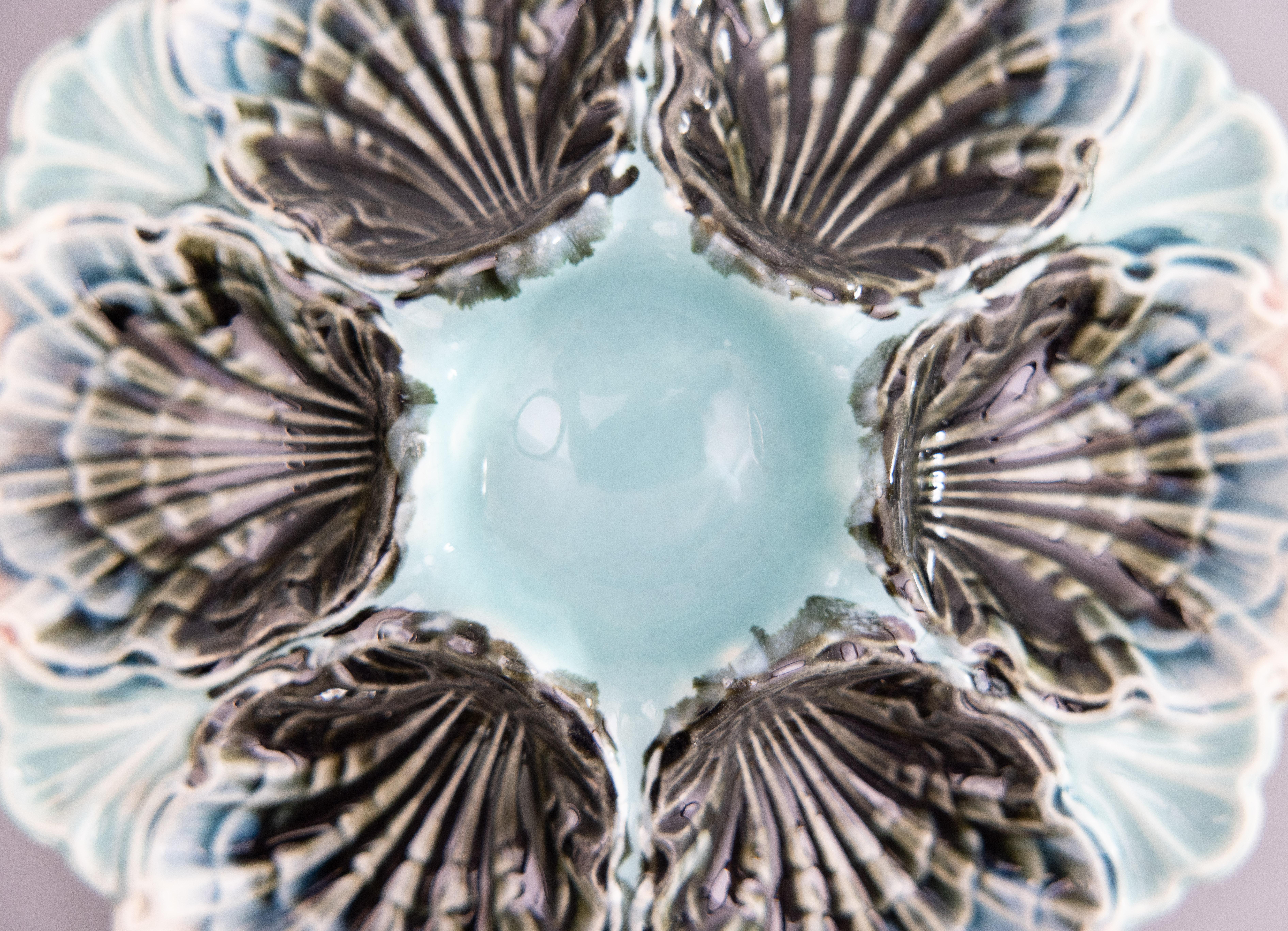 A gorgeous antique French majolica oyster plate made by Fives-Lille, circa 1890. This fine quality oyster plate is hand painted in a beautiful light aqua blue / turquoise color with soft pink edges. It displays beautifully and would also be perfect