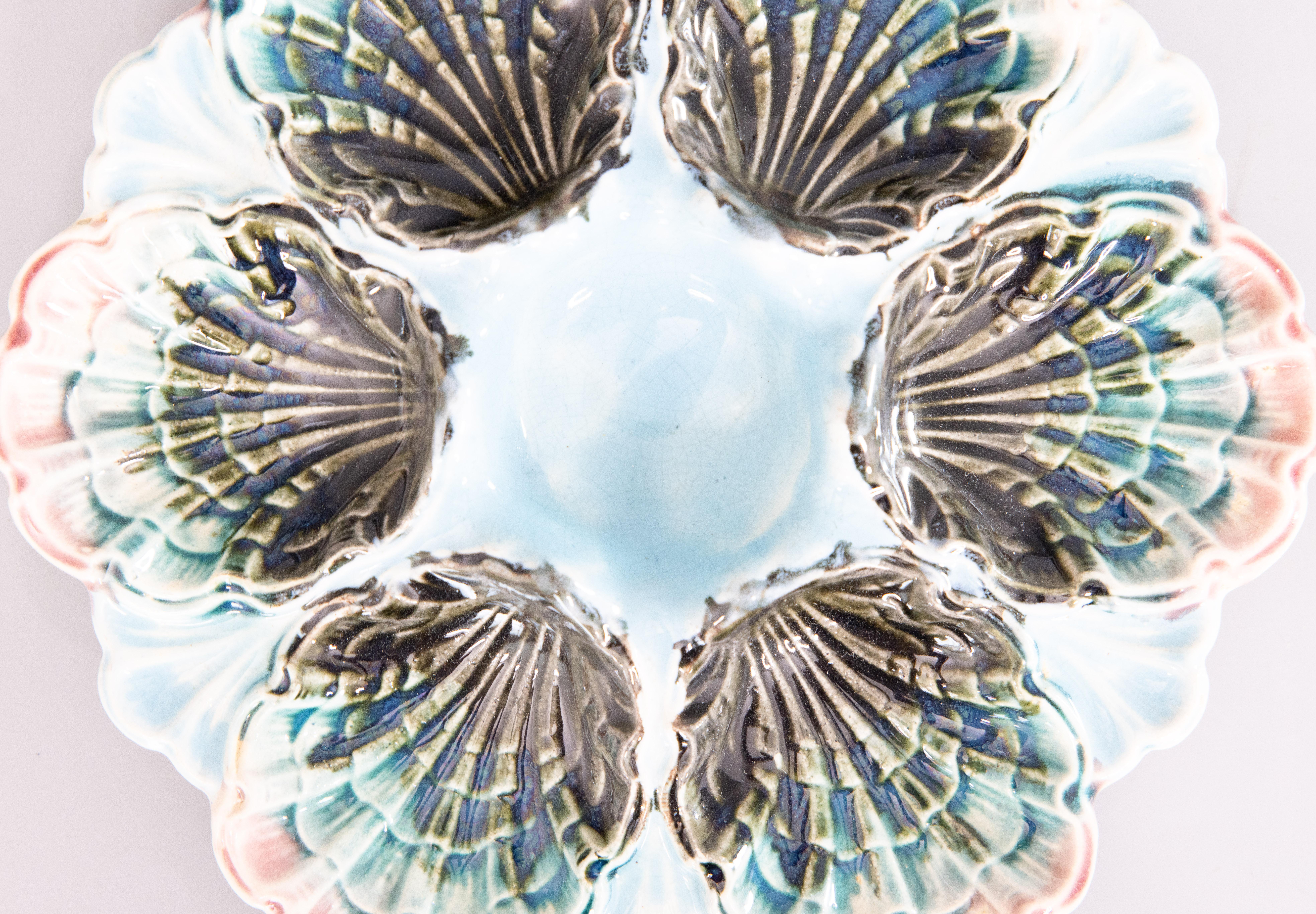 A gorgeous antique French majolica oyster plate made by Fives-Lille, circa 1890. This fine quality oyster plate is hand painted in a beautiful light aqua blue / turquoise color with rose pink edges. It displays beautifully and would also be perfect