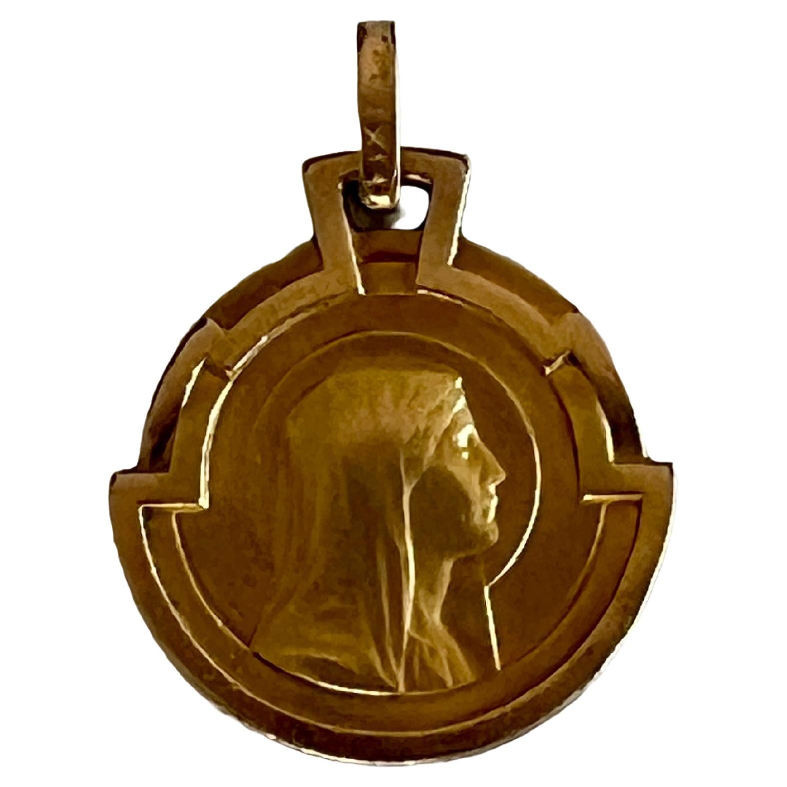 This exquisite vintage pendant showcases the revered Virgin Mary in a serene profile, meticulously crafted to highlight her gentle features and the folds of her veil. The pendant is framed by a distinctive geometric design, reflecting the Art Deco